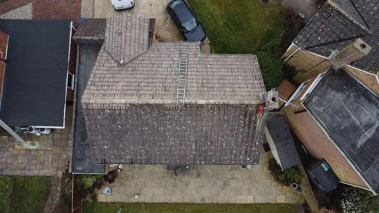 Overhead drone shot showing one elevation fully cleaned and sealed after de-mossing.