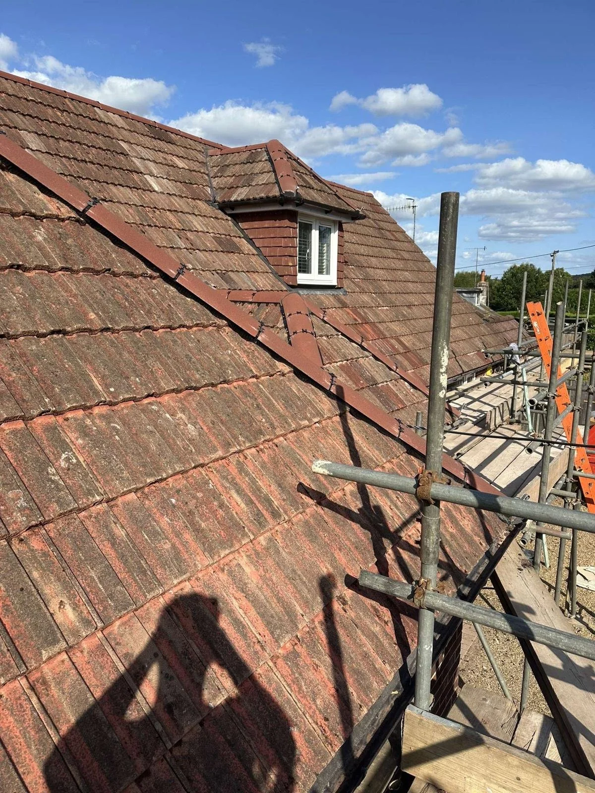 Progress across lower roof sections with reused tiles fitted neatly.
