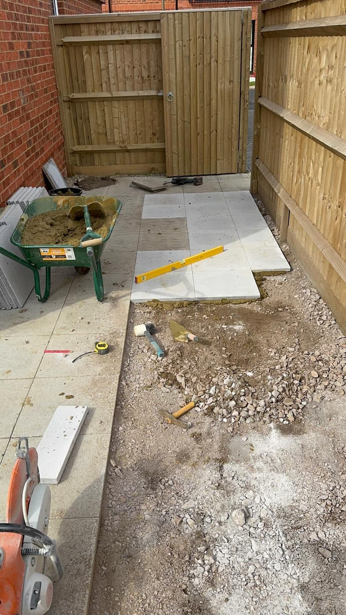 Ground prepared and slabs positioned for levelling during the patio extension in Cranleigh, Surrey.