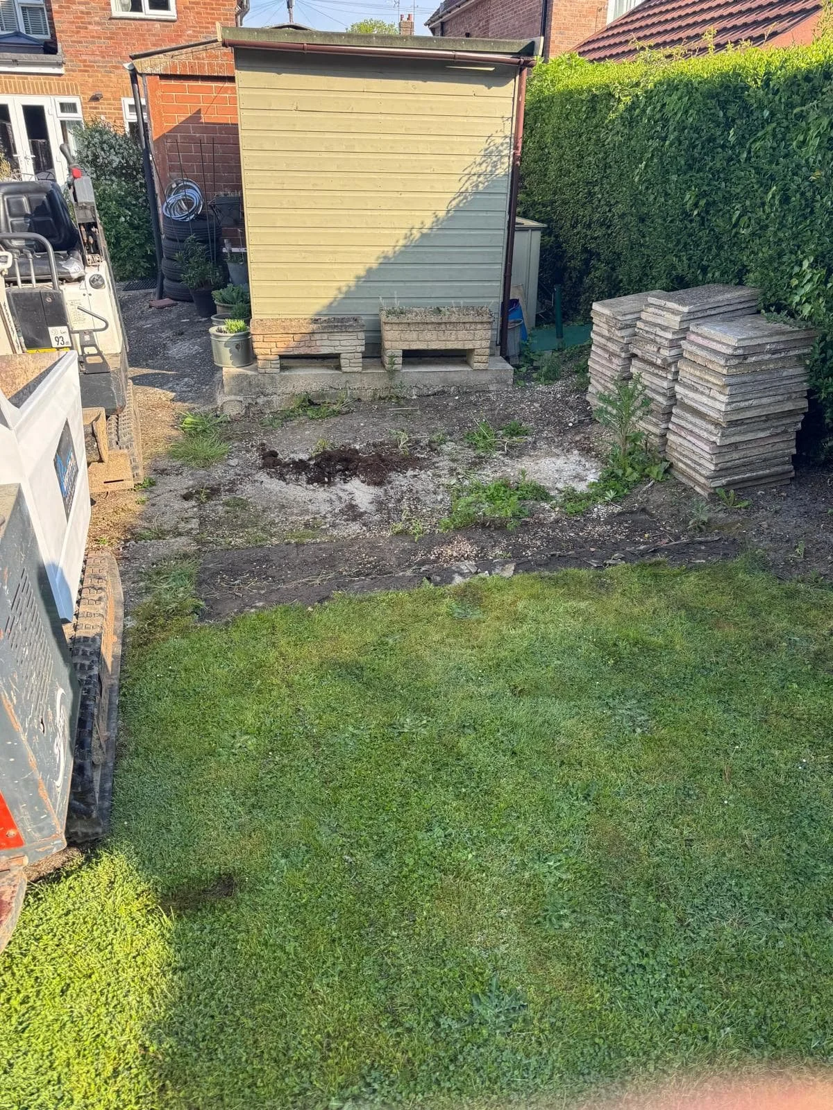 Existing patio area before work began, with old slabs stacked and the ground cleared for the new installation in Cranleigh.