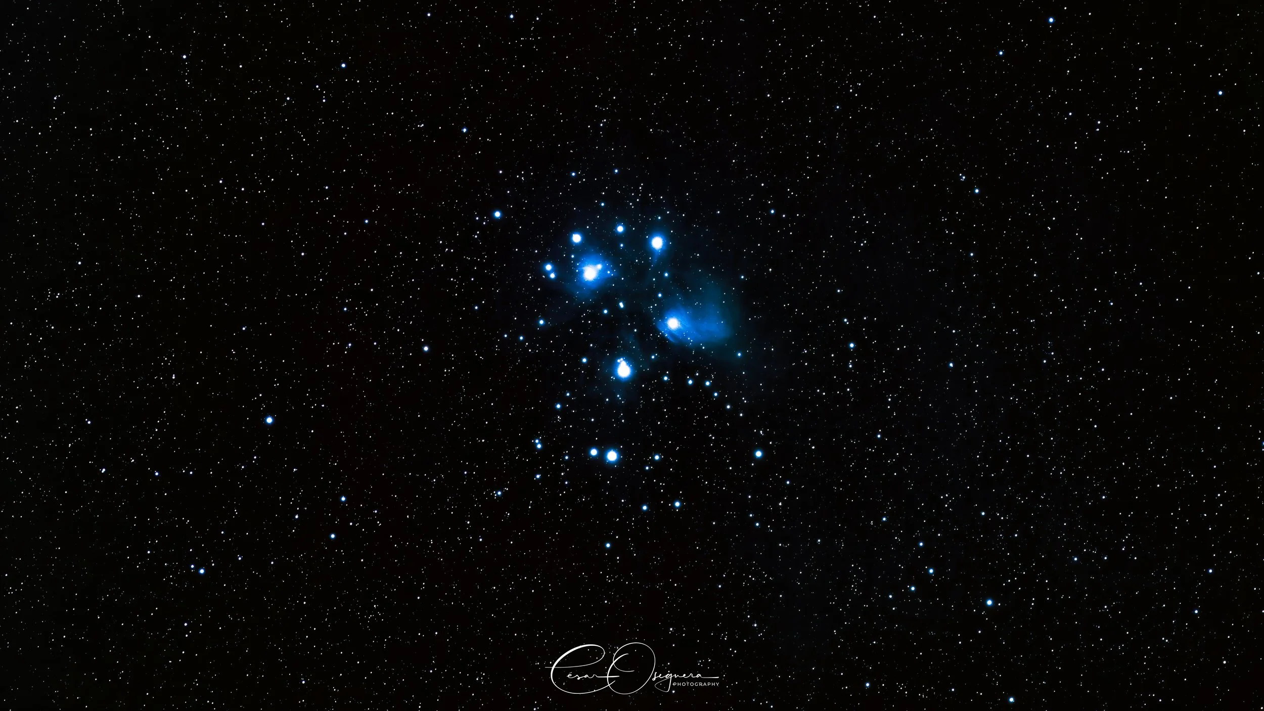 A starry night sky with the Orion Nebula, a bright, colorful region of space with clusters of stars and cosmic dust.