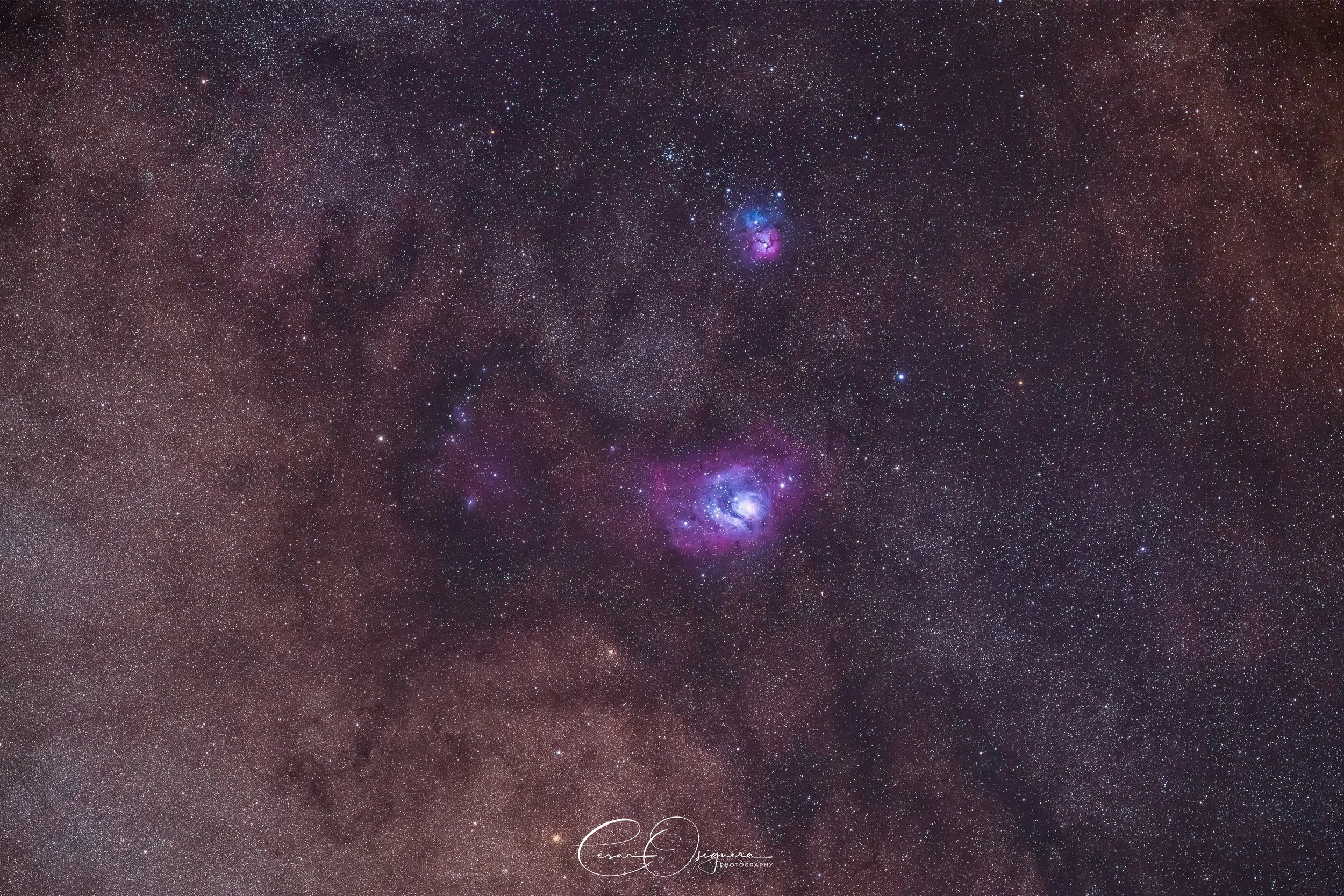 A detailed image of a star-filled night sky with colorful nebulae, including the Orion Nebula, against a dark background.