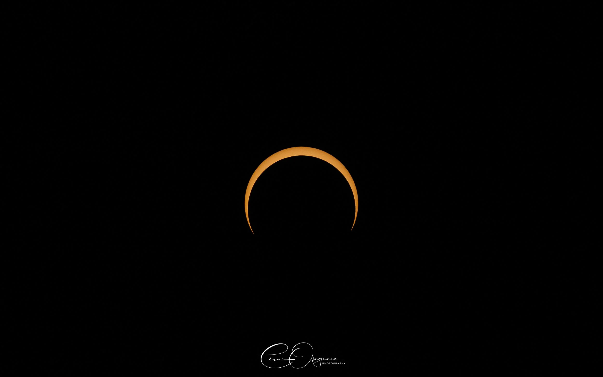 A partial solar eclipse, showing the moon covering most of the sun against a dark sky