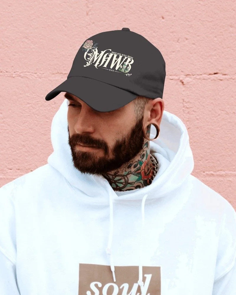 A man posing with a white hoodie and black hat