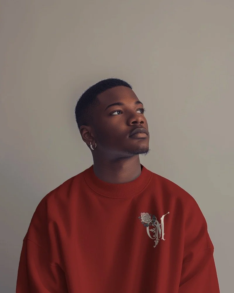 A man posing to the side wearing a red sweatshirt