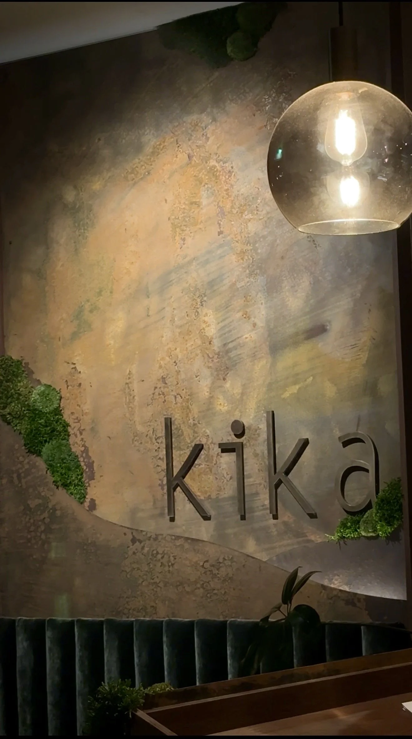 Moody restaurant interior branding wall with Kika signage and warm ambient lighting in Wānaka