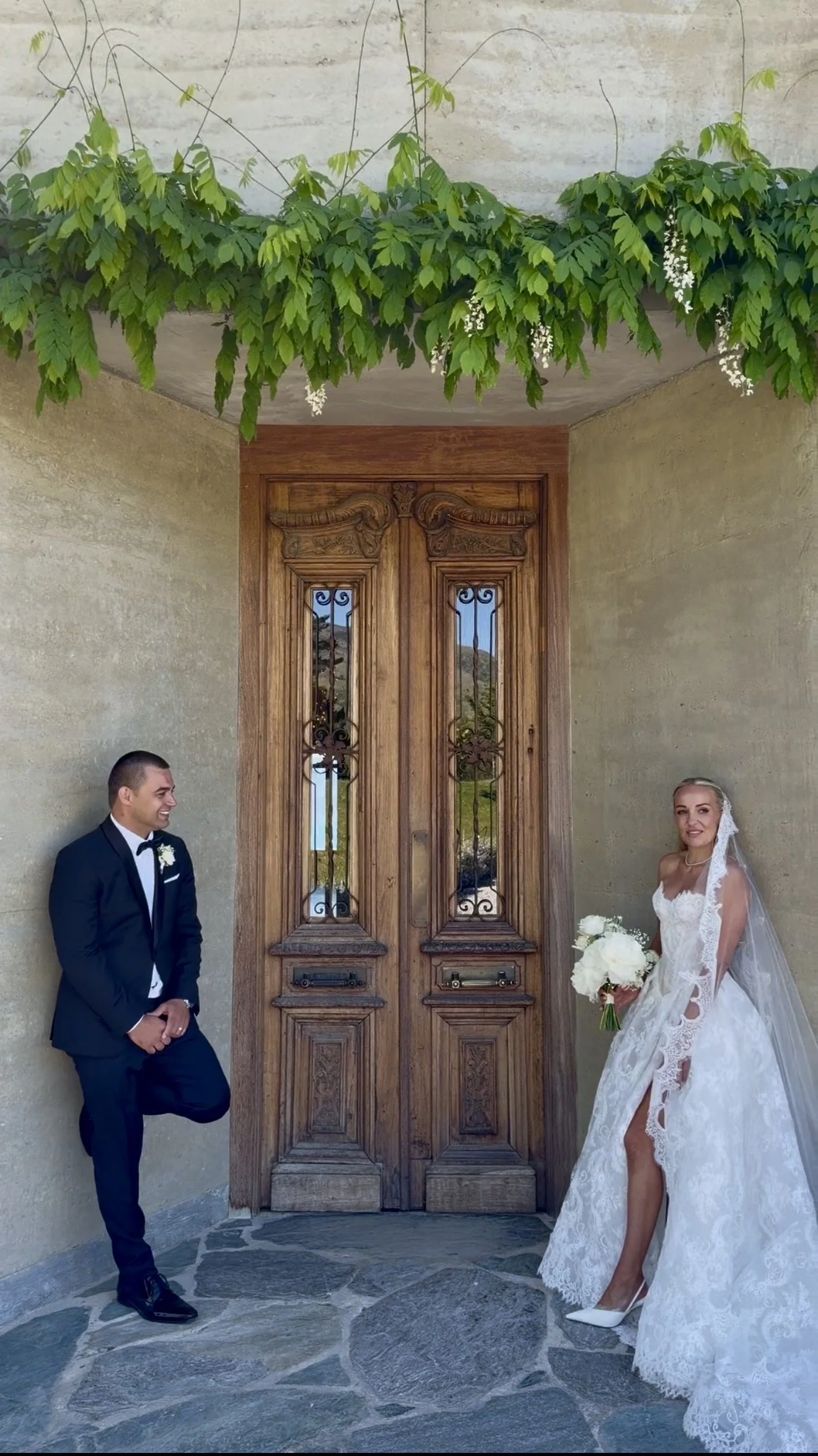 Bride and groom portrait at elegant Central Otago wedding venue with rustic wooden doors and editorial styling