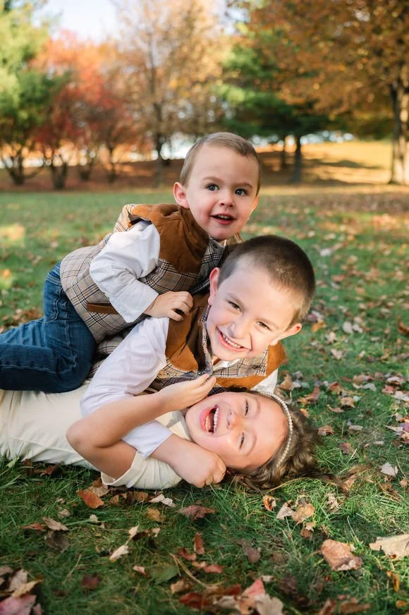 Children laughing and playing together during a family session