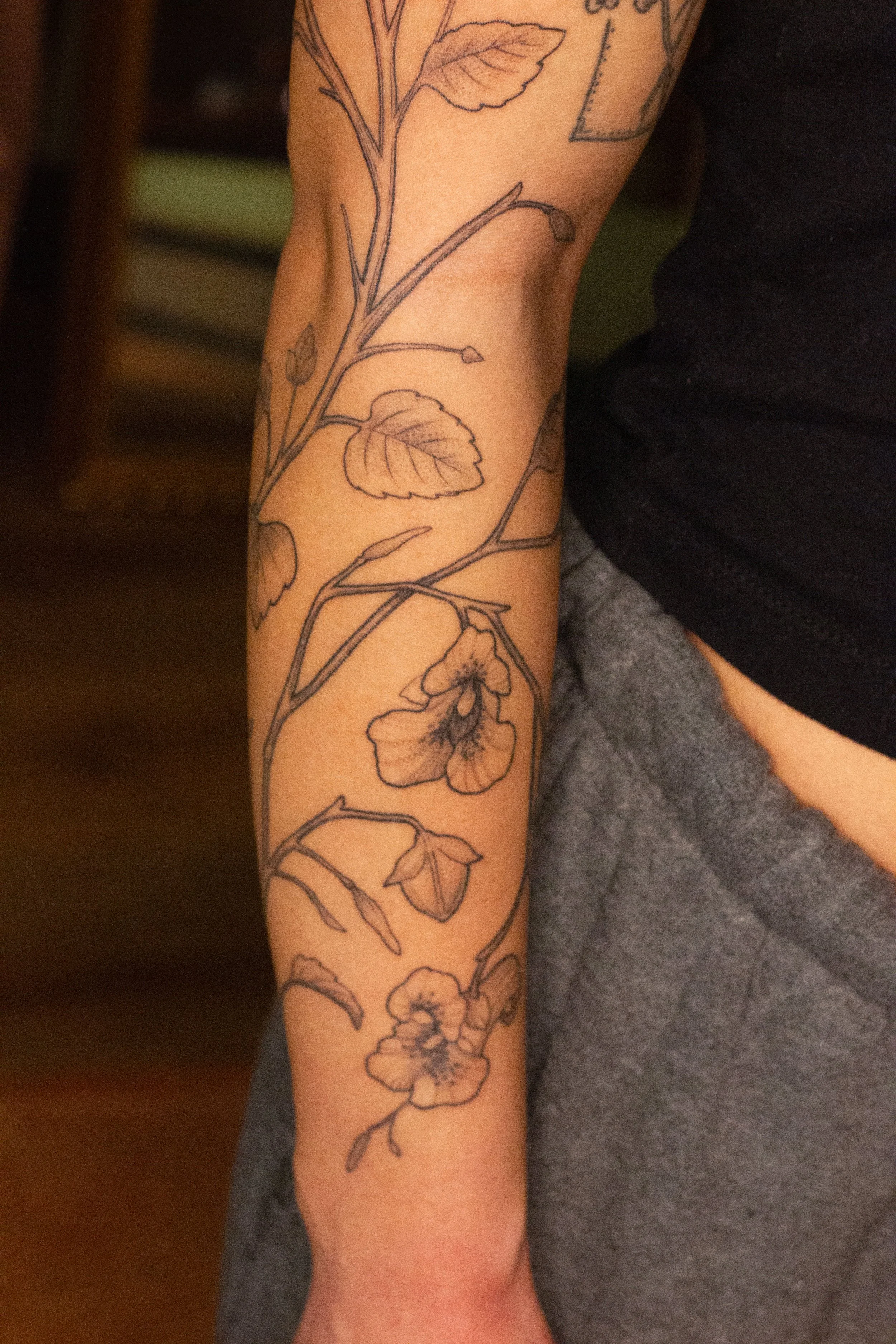 December 2025 · Freehand wrapping Jewelweed, top half of arm is freshly tattooed and bottom half of arm is six days into healing
