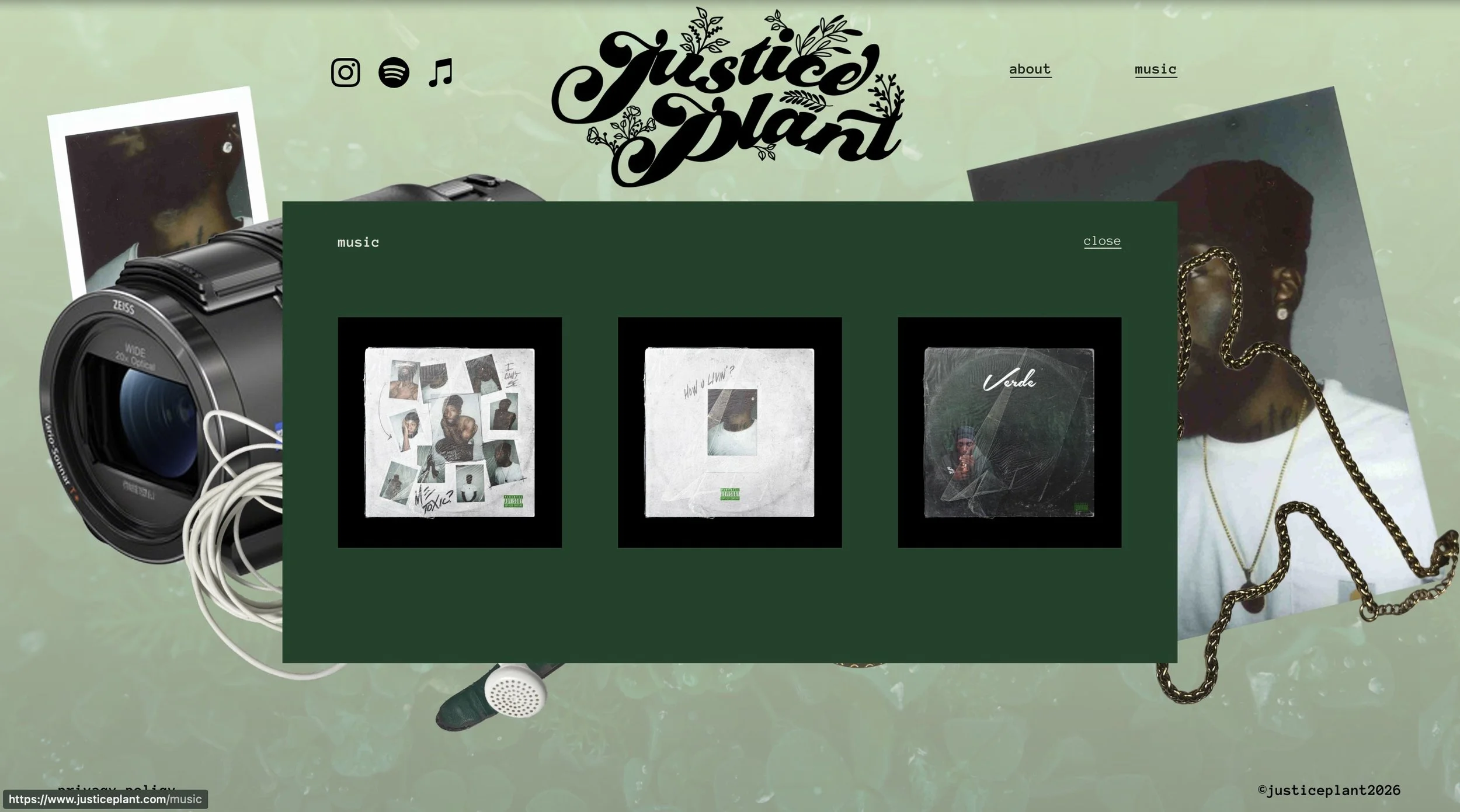 Website page for Justice Plant music label featuring album covers in a green overlay, with a camera, photographs, and jewelry in the background.