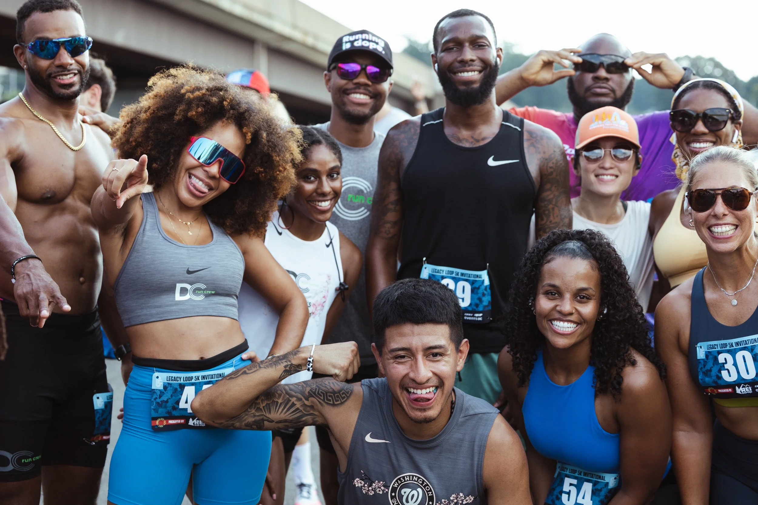 Group of people running and smiling on the street during a marathon or fun run event, black and white photo.