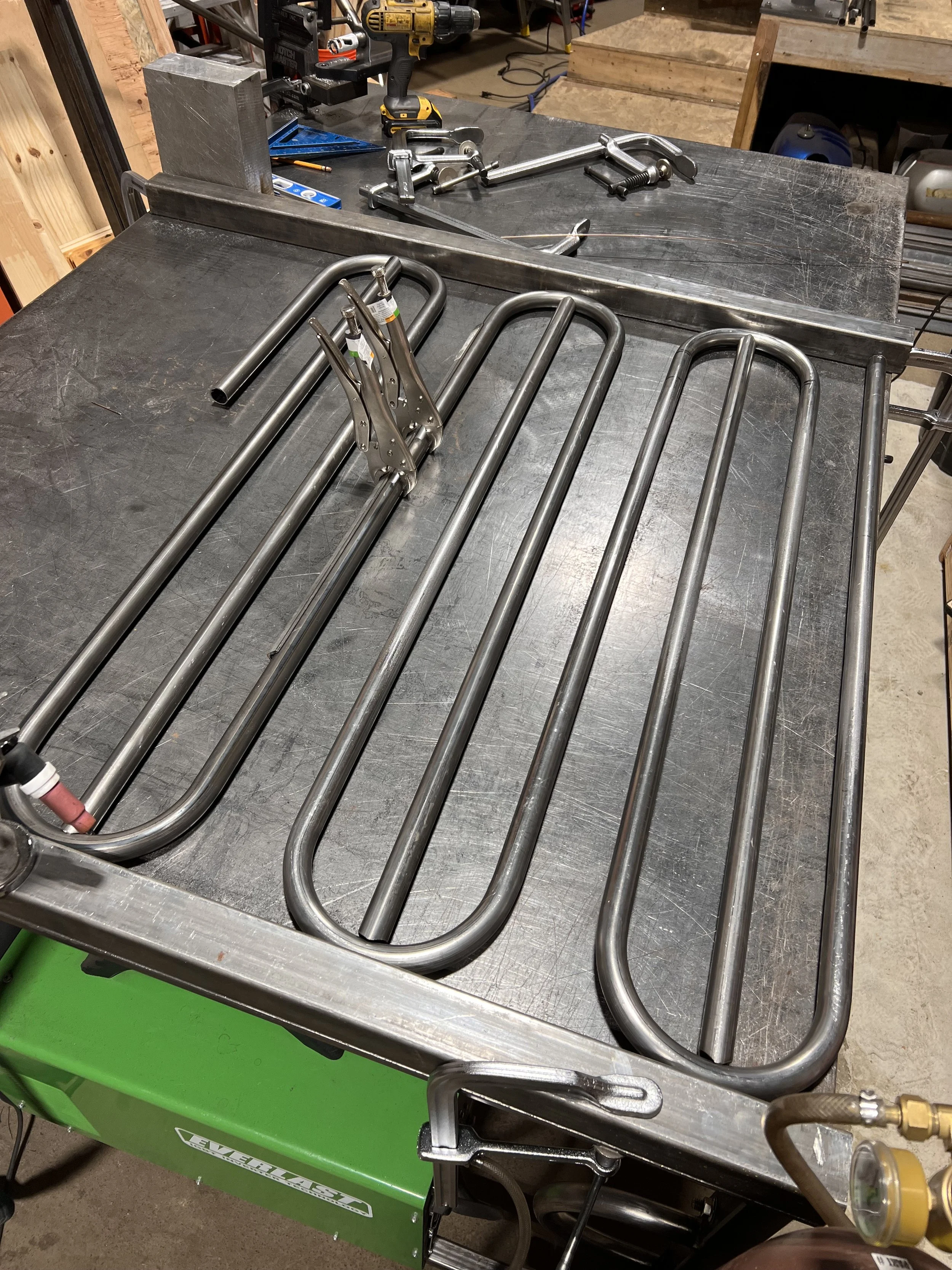 Fit-up of the hand-bent tubular steel railing components for the Love & Hominy parklet, showing the repeating interlocking geometry developed by de stijl FORMS.