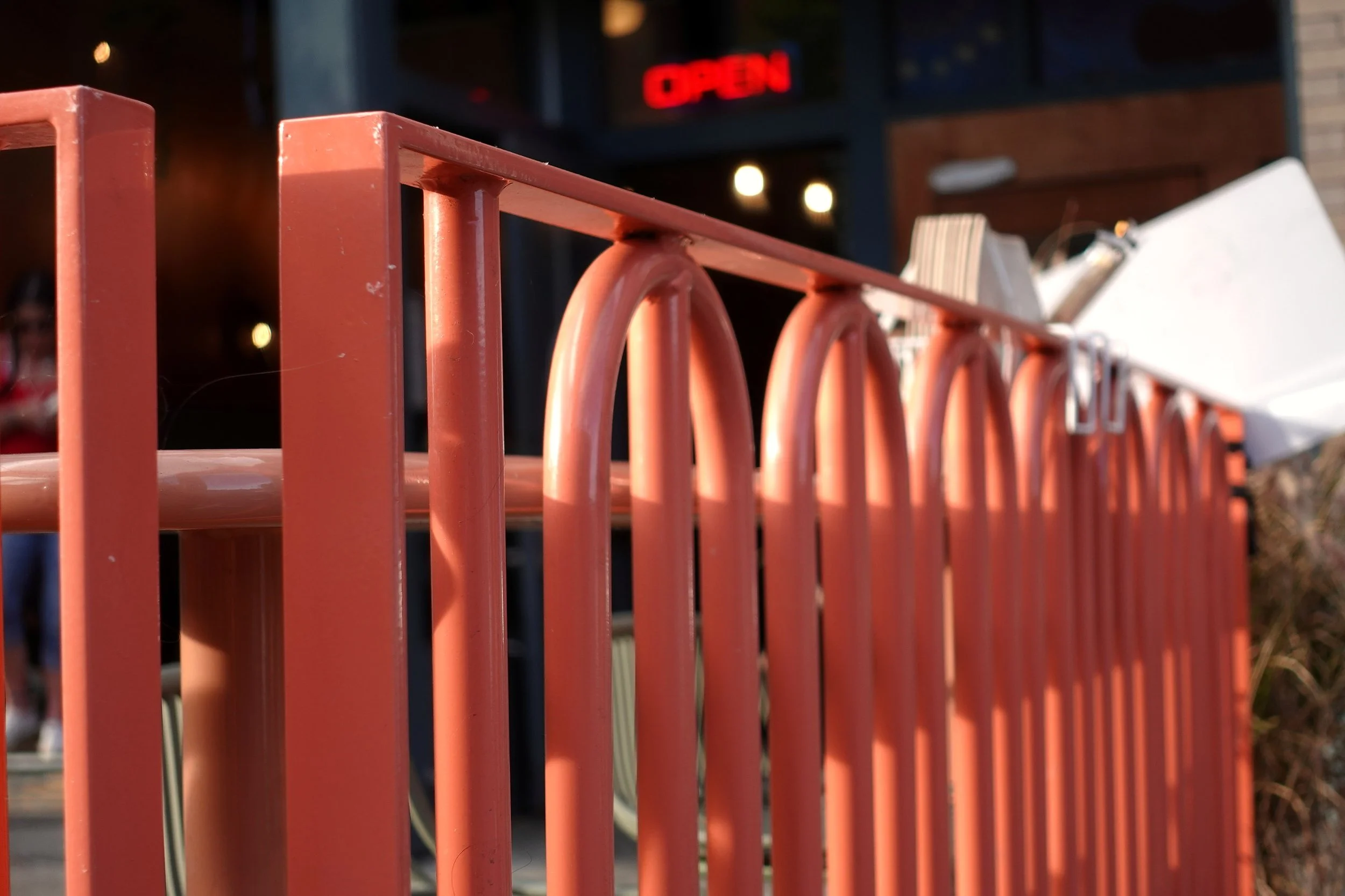 Detail of the finished coral steel railing at Love & Hominy, featuring the original interlocking tubular geometry developed and fabricated by de stijl FORMS.