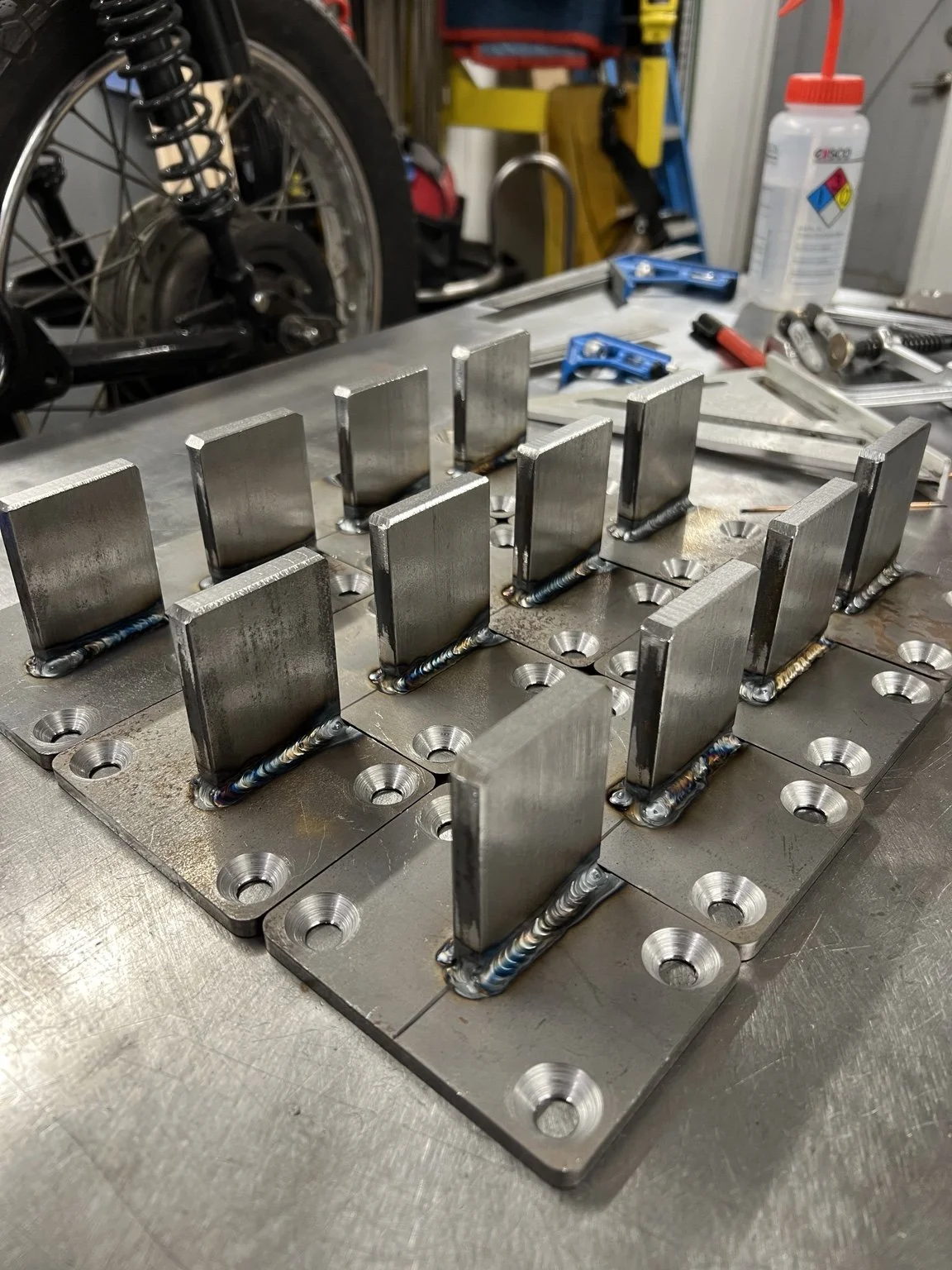 Purpose-built steel railing connection assemblies during fabrication for The York, combining custom-cut plates, welded components, and mechanical fasteners into a mounting system designed specifically for the project.