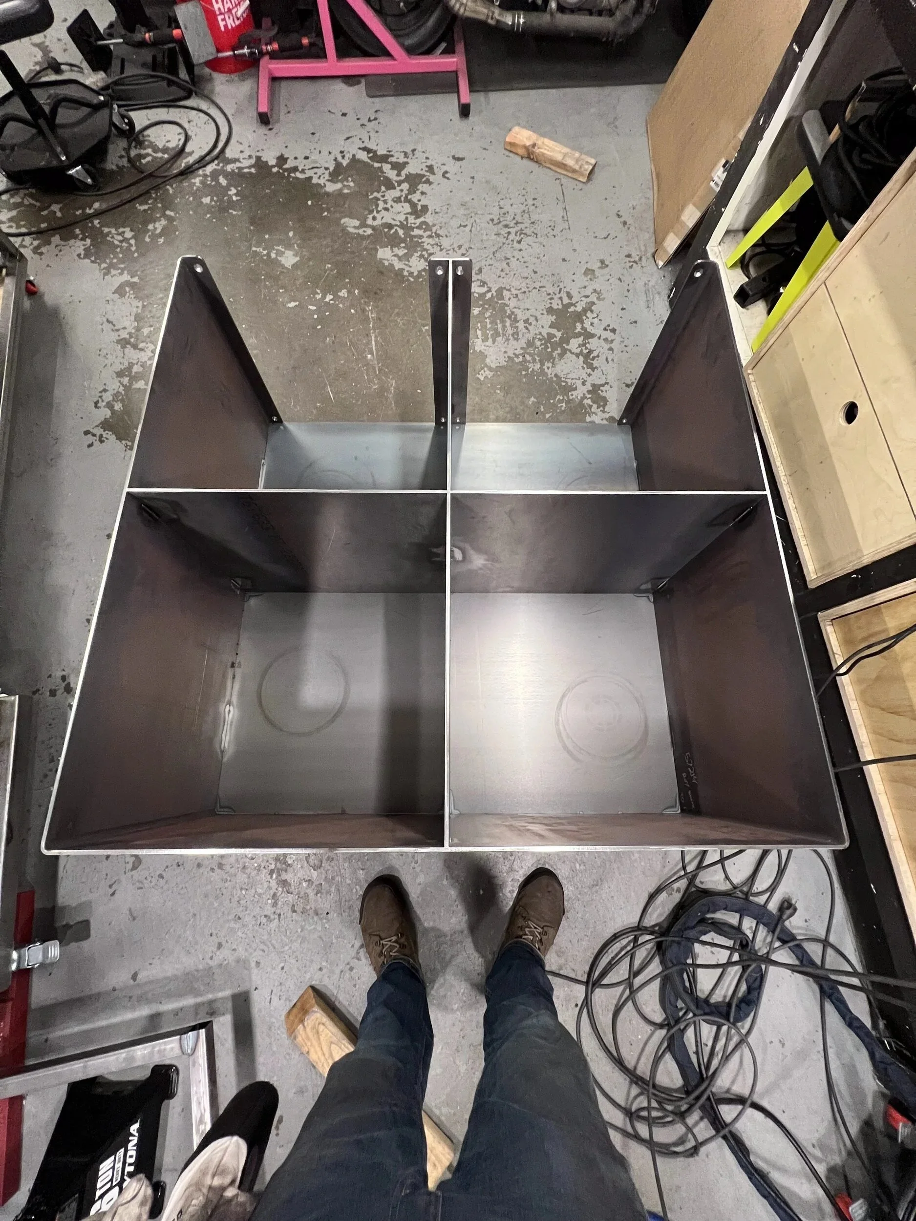 Raw steel firewood box with a center divider, assembled in the shop before finishing — designed and fabricated by de stijl FORMS in Hood River, Oregon.