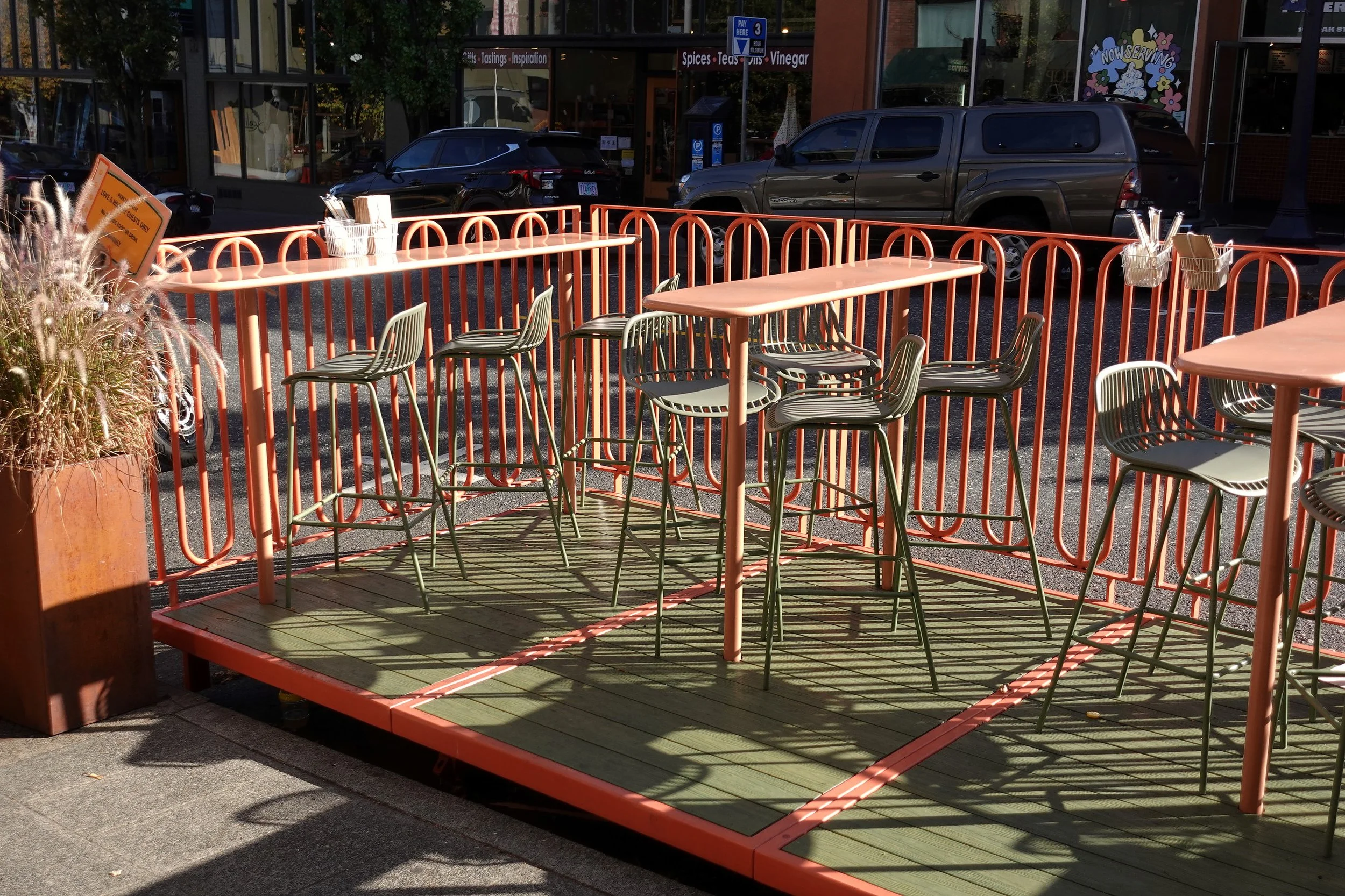 Love & Hominy parklet seating area in Hood River, Oregon, showing the relationship between the integrated tables, composite decking, and custom steel railing system.