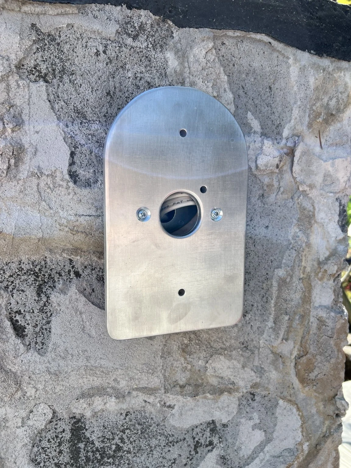 Fabricated aluminum mounting assembly for a Schoolhouse exterior sconce, showing the project-specific tabs and connection details developed to position the fixture cleanly against the masonry at The York.