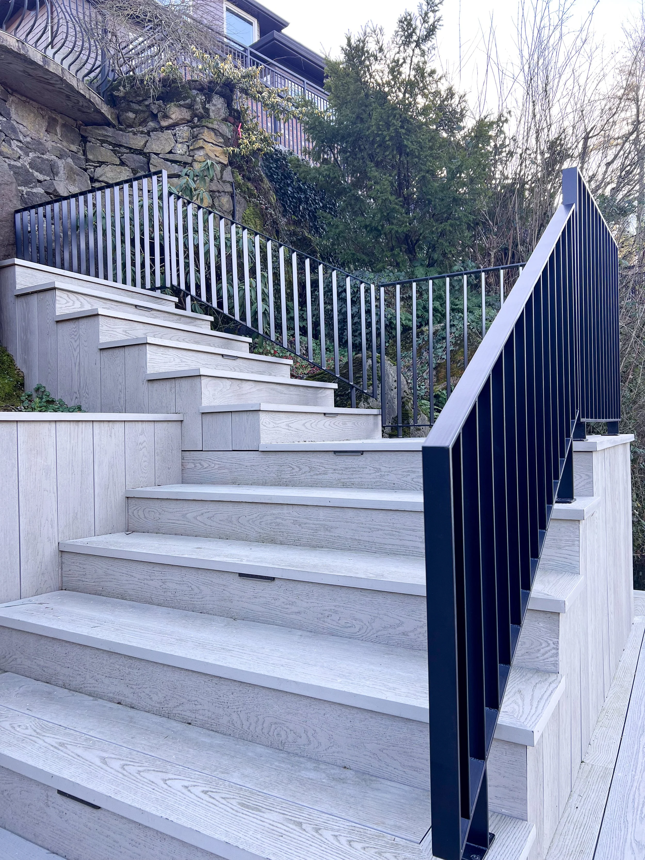 Custom black steel stair railing following the exterior stairs at The York residence in Lake Oswego, Oregon, designed and fabricated by de stijl FORMS.