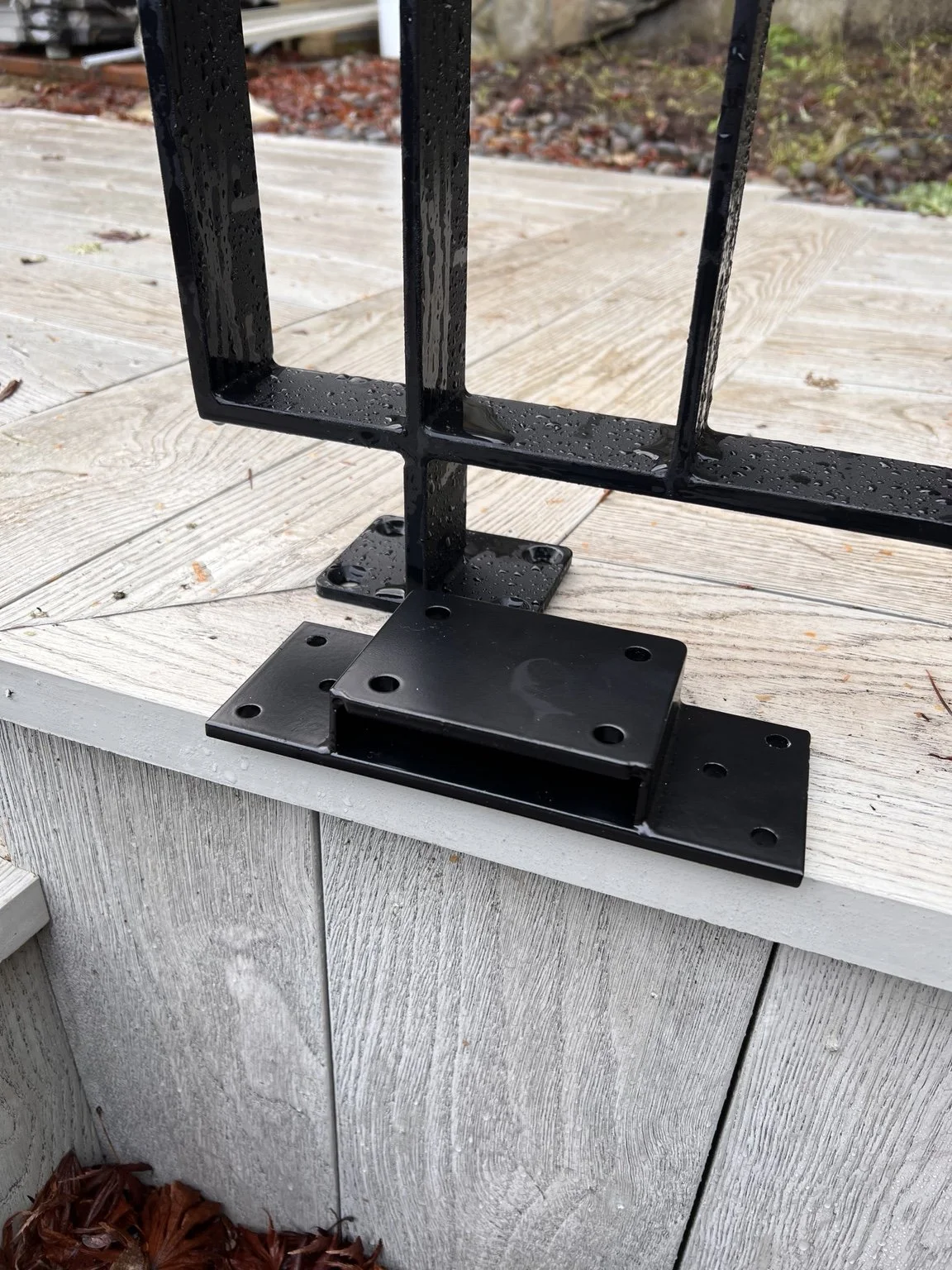 Finished custom steel railing connection installed at The York in Lake Oswego, Oregon, showing how the project-specific mounting system integrates the architectural metalwork cleanly into the surrounding deck construction.