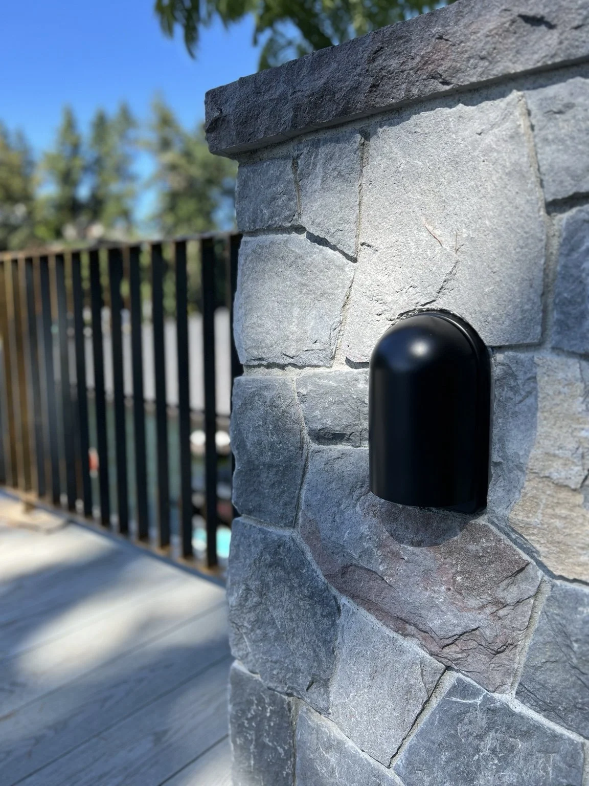 Finished Schoolhouse exterior sconce installed with the custom aluminum mounting plate at The York in Lake Oswego, Oregon, creating a clean transition between the light fixture and the home’s masonry architecture.
