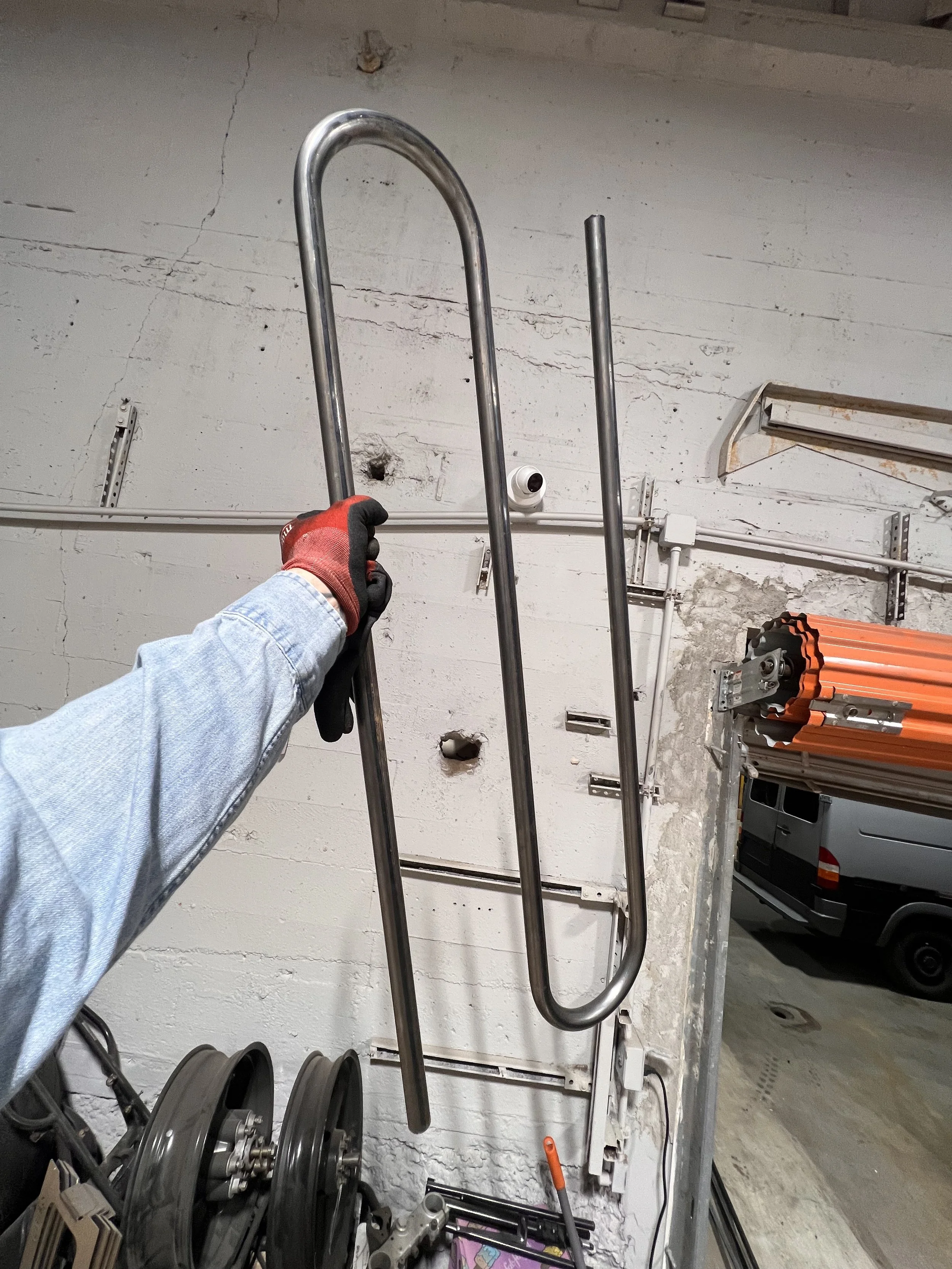 Individual hand-bent steel railing component shown during fabrication, illustrating the loop geometry used to create the parklet’s repeating tessellated pattern.