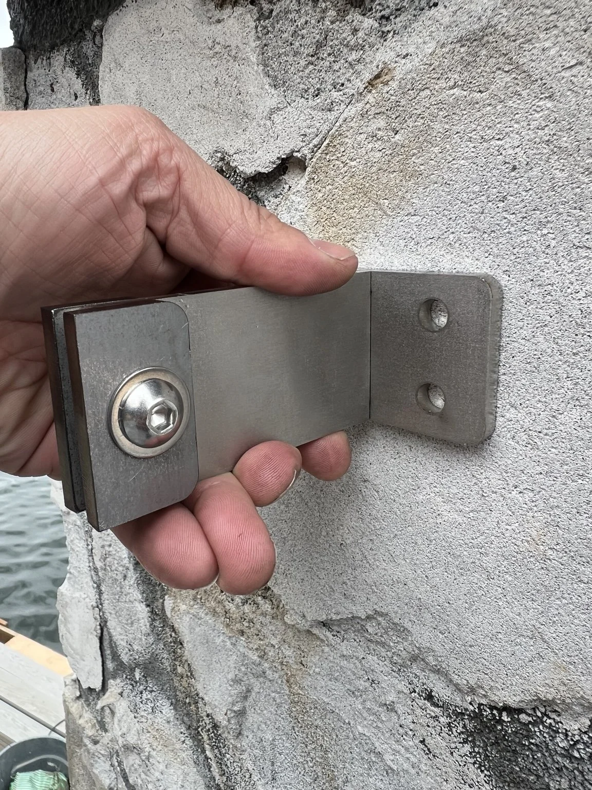 Site fitting of the custom stainless steel mounting connection, developed to resolve the specific architectural conditions of The York railing installation in Lake Oswego, Oregon.