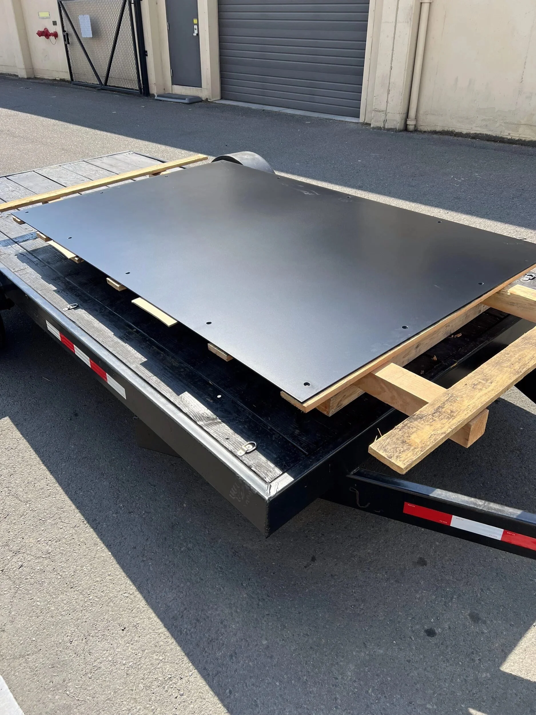 Roughly 300-pound steel hearth plate on a pallet, ready for delivery — designed and fabricated by de stijl FORMS in Hood River, Oregon.