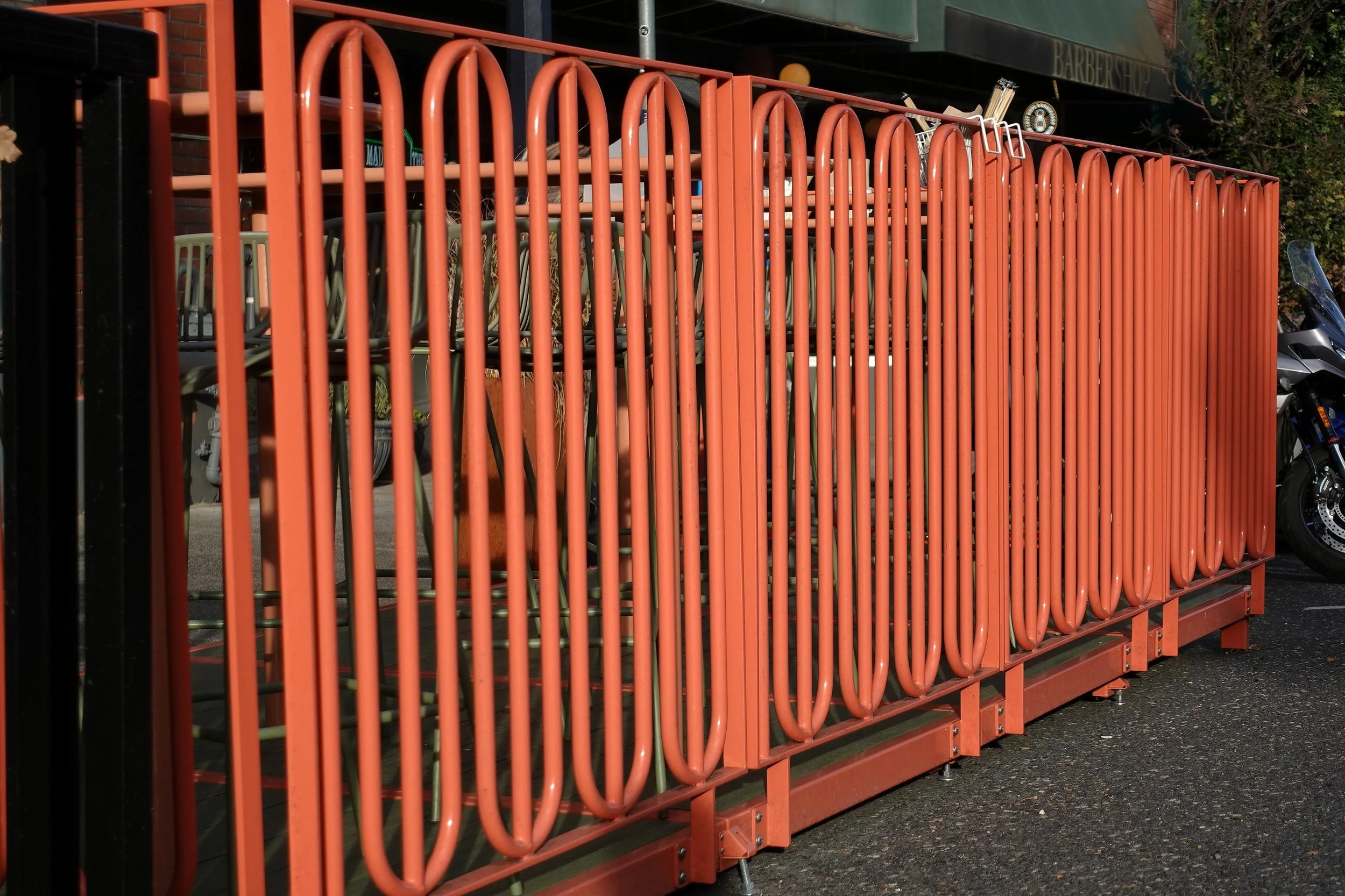 Custom steel railing designed and fabricated by de stijl FORMS for the Love & Hominy parklet, featuring an original interlocking pattern of hand-bent tubular steel.