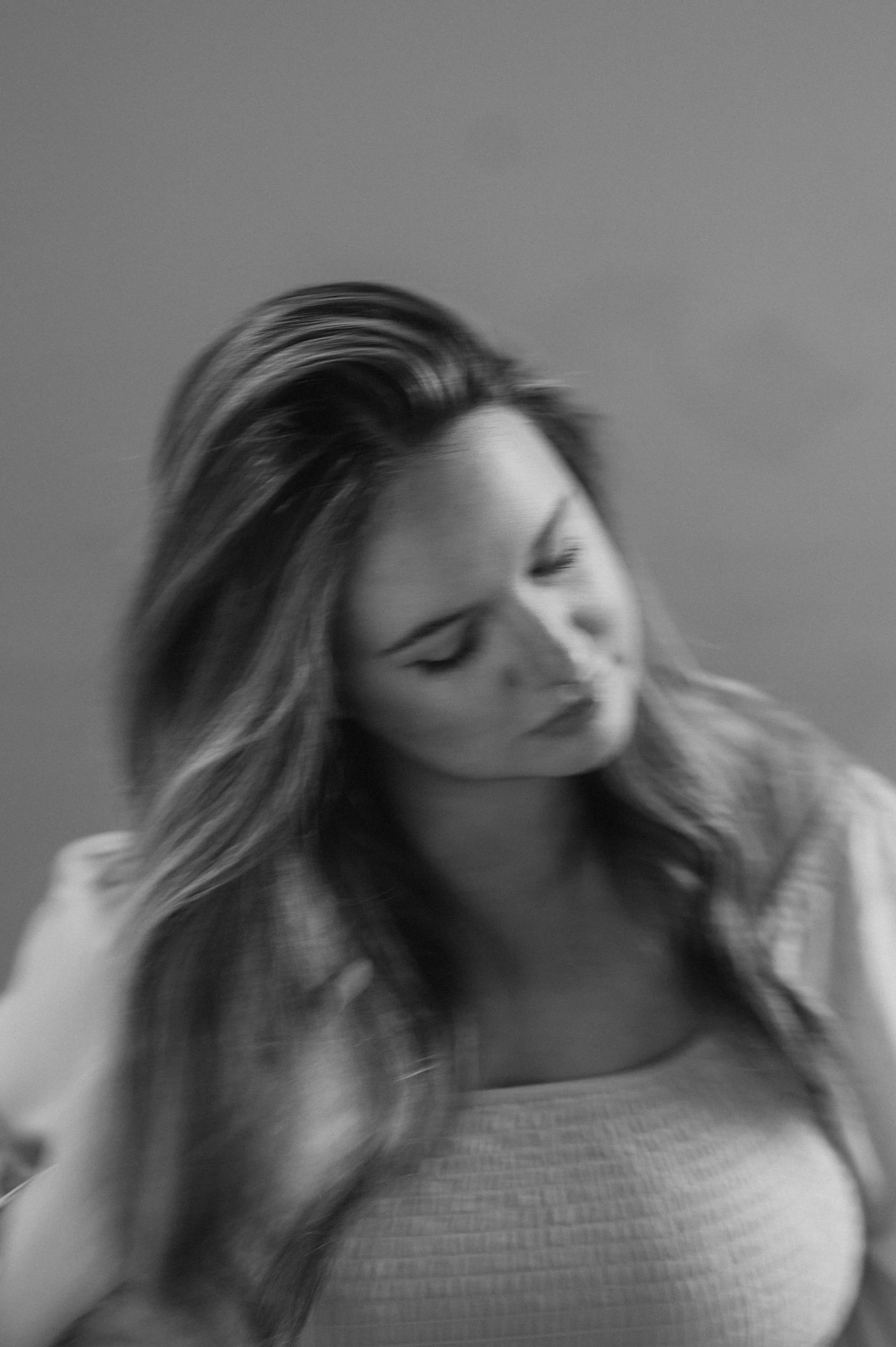 Black and white photo of a woman with long hair looking down
