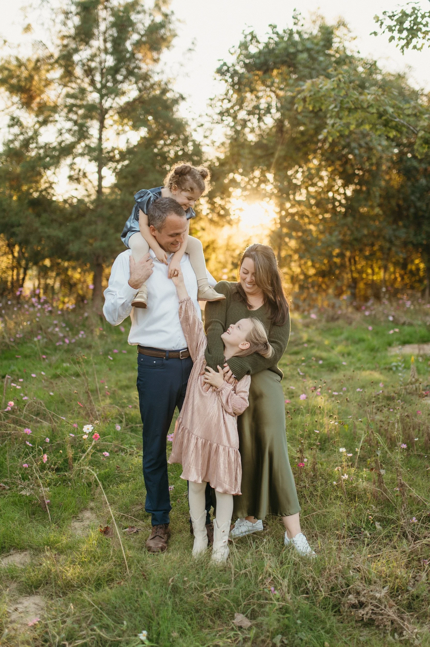 A mother and her two daughters huddle close, while the wind blows their hair across the image frame