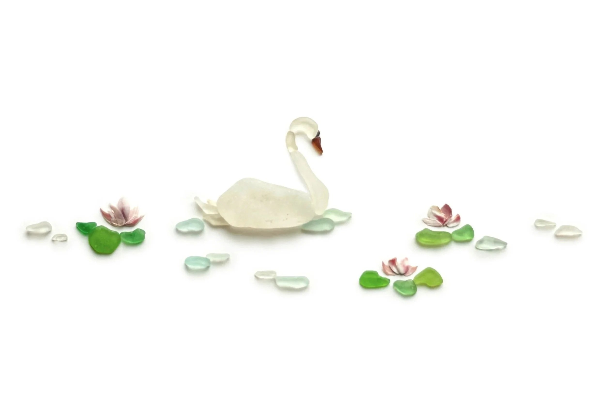 Original sea glass artwork featuring a graceful white swan with a curved neck, surrounded by pink water lilies, green lily pads, and pale aqua sea glass ripples on a lake against a white background.
