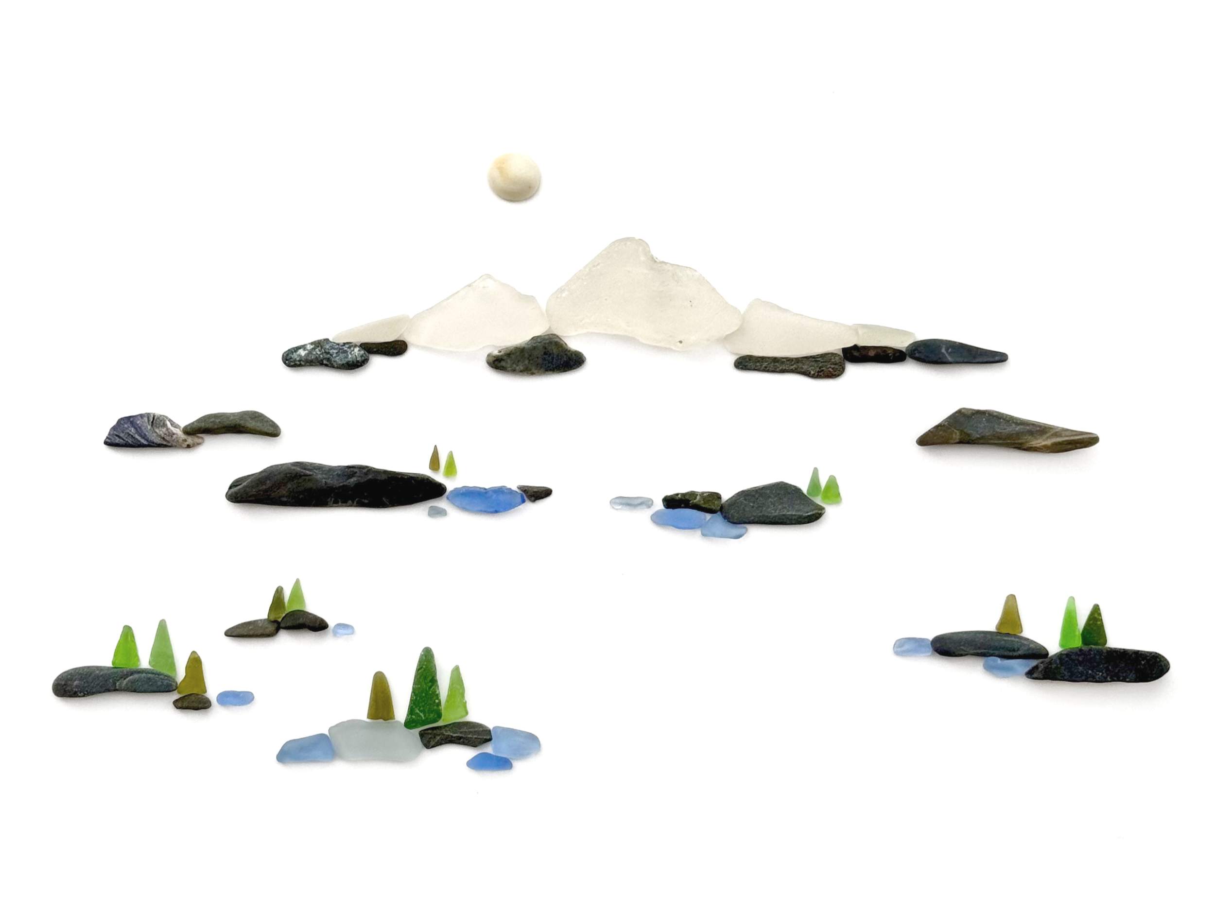 A minimalist Mt. Shasta landscape created with white sea glass, beach stones, and with blue and green glass forest lake scene below. 