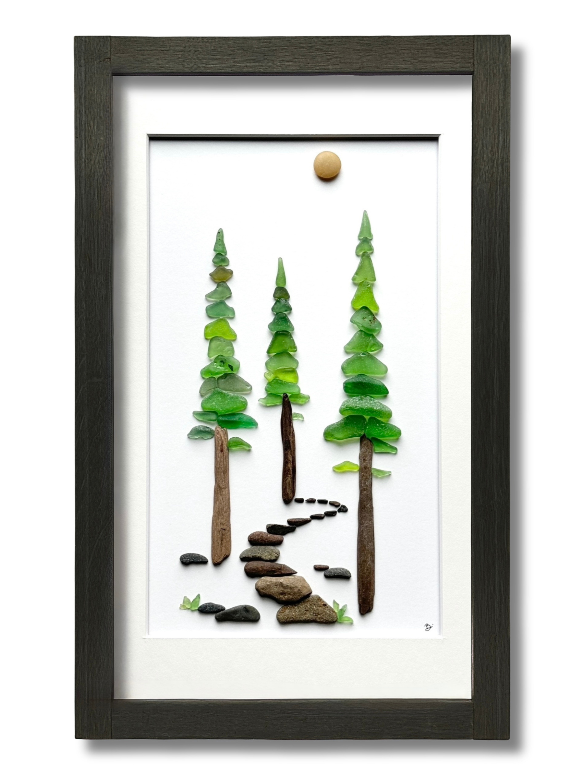 A framed redwood forest created with layered green sea glass and a winding path of smooth beach stones.