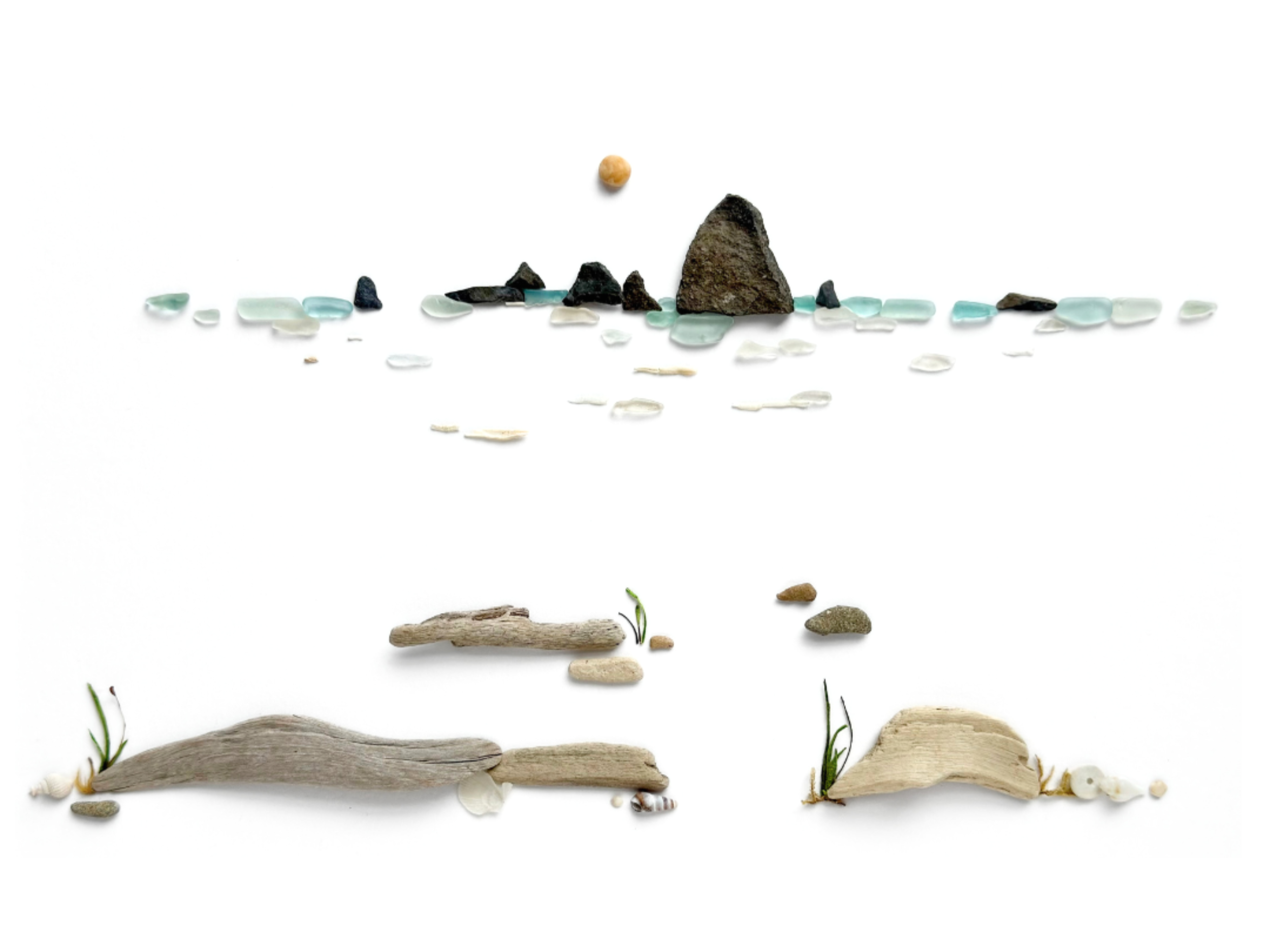 Abstract coastal horizon created with sea glass, beach stones, driftwood, and delicate water details.