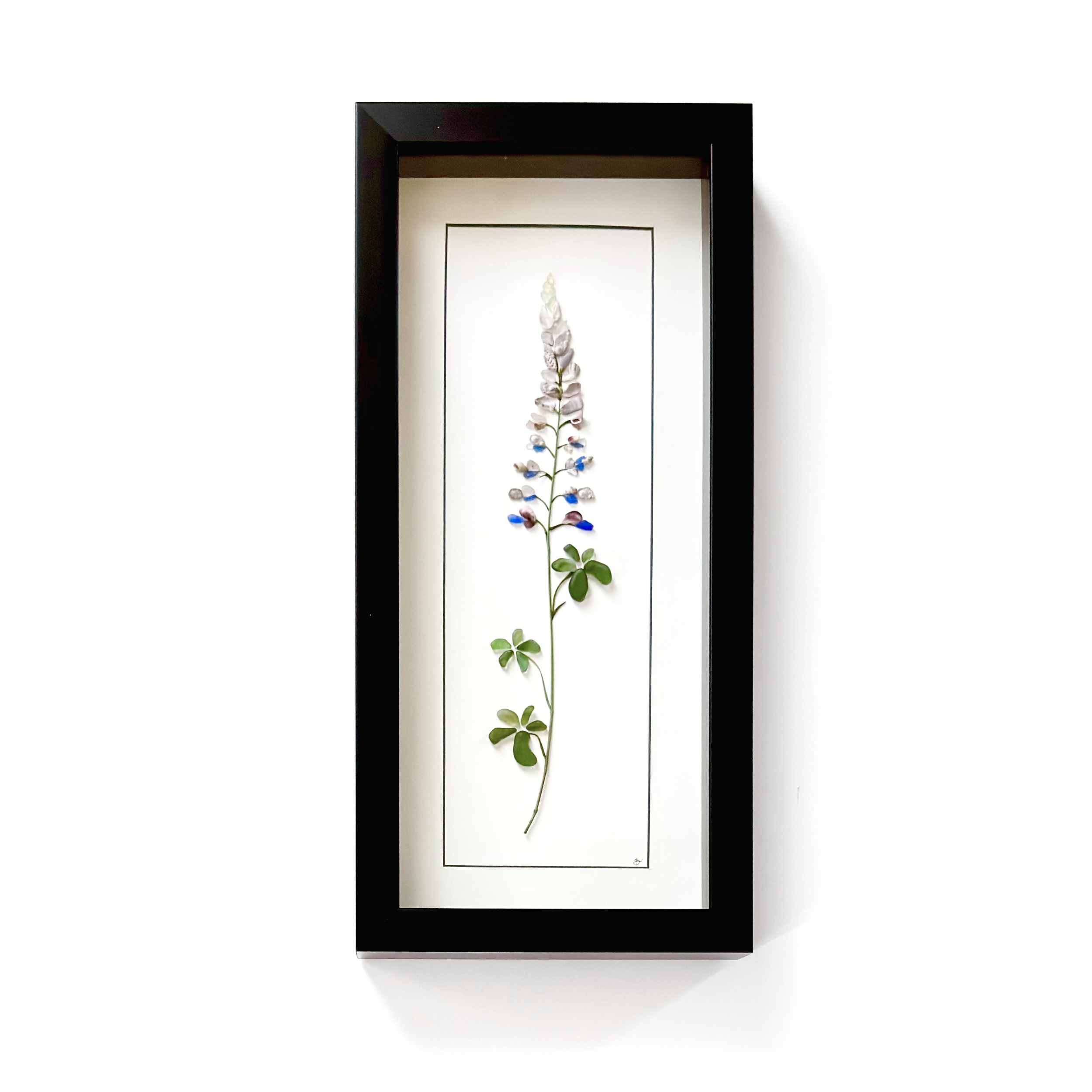Tall sea glass lupine displayed in a black shadowbox frame on a white background.