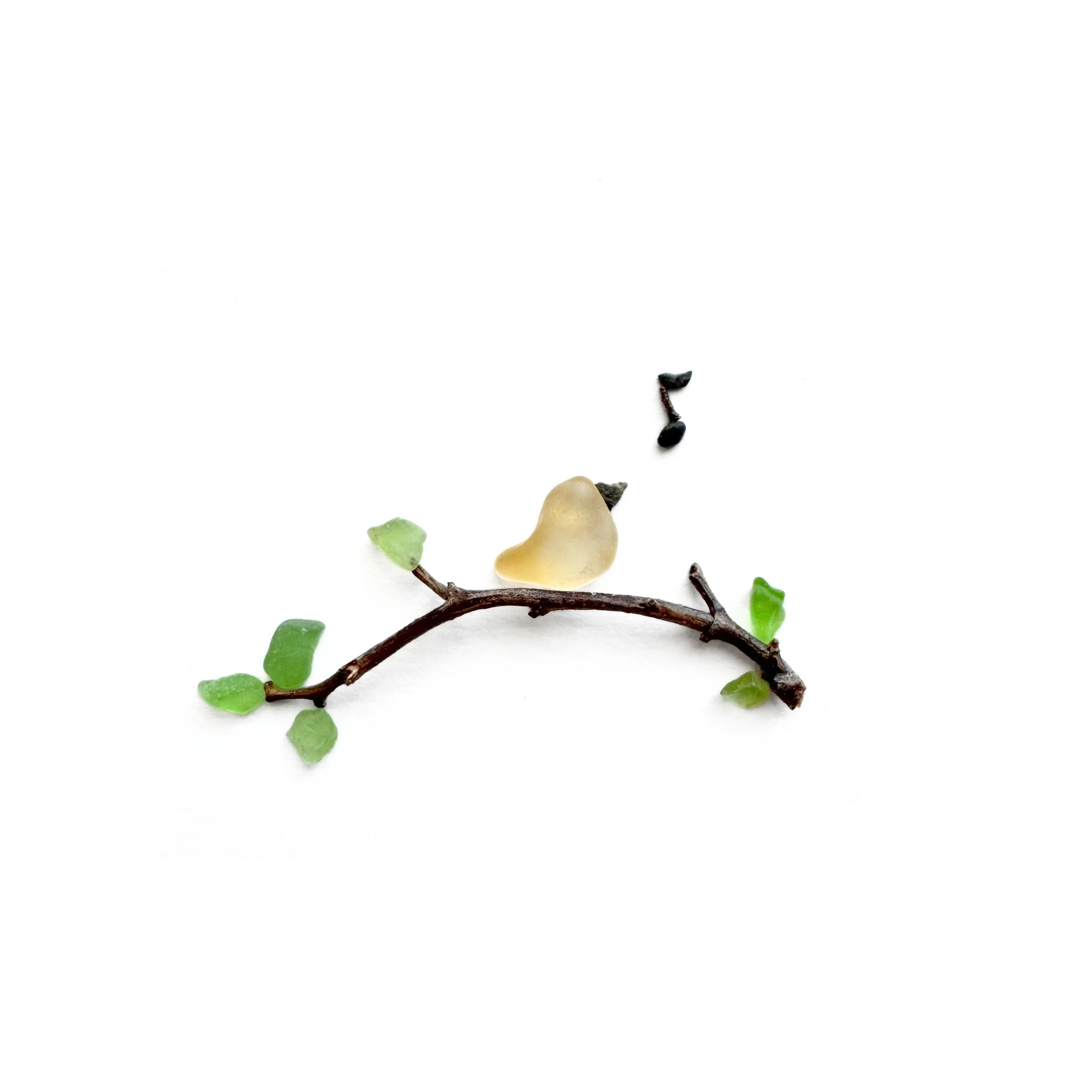Original sea glass artwork featuring a small yellow songbird perched on a curved grapevine branch with green sea glass leaves and a black musical note against a white background.