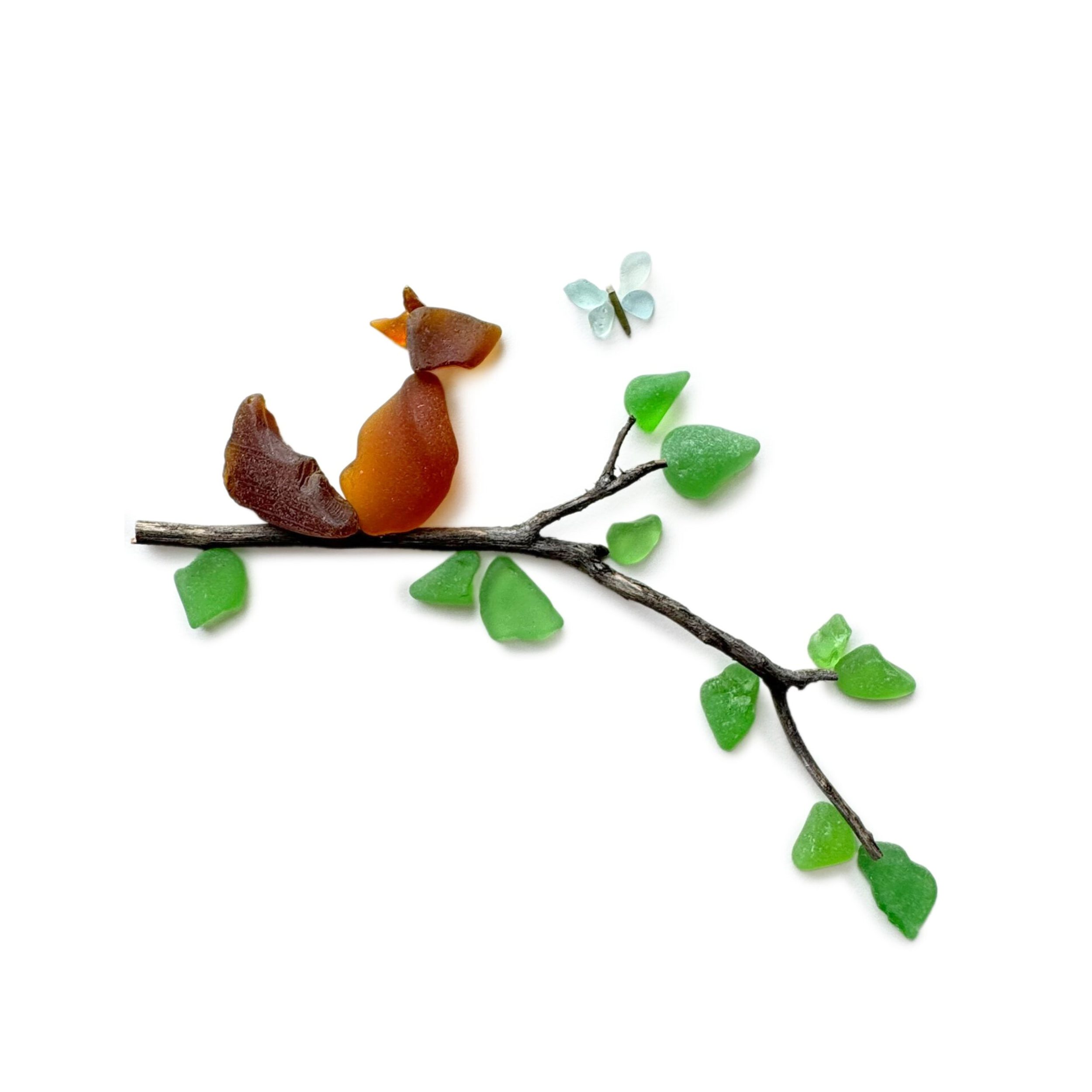 Minimalist sea glass artwork of a squirrel perched on a driftwood branch with green sea glass leaves and a blue butterfly.