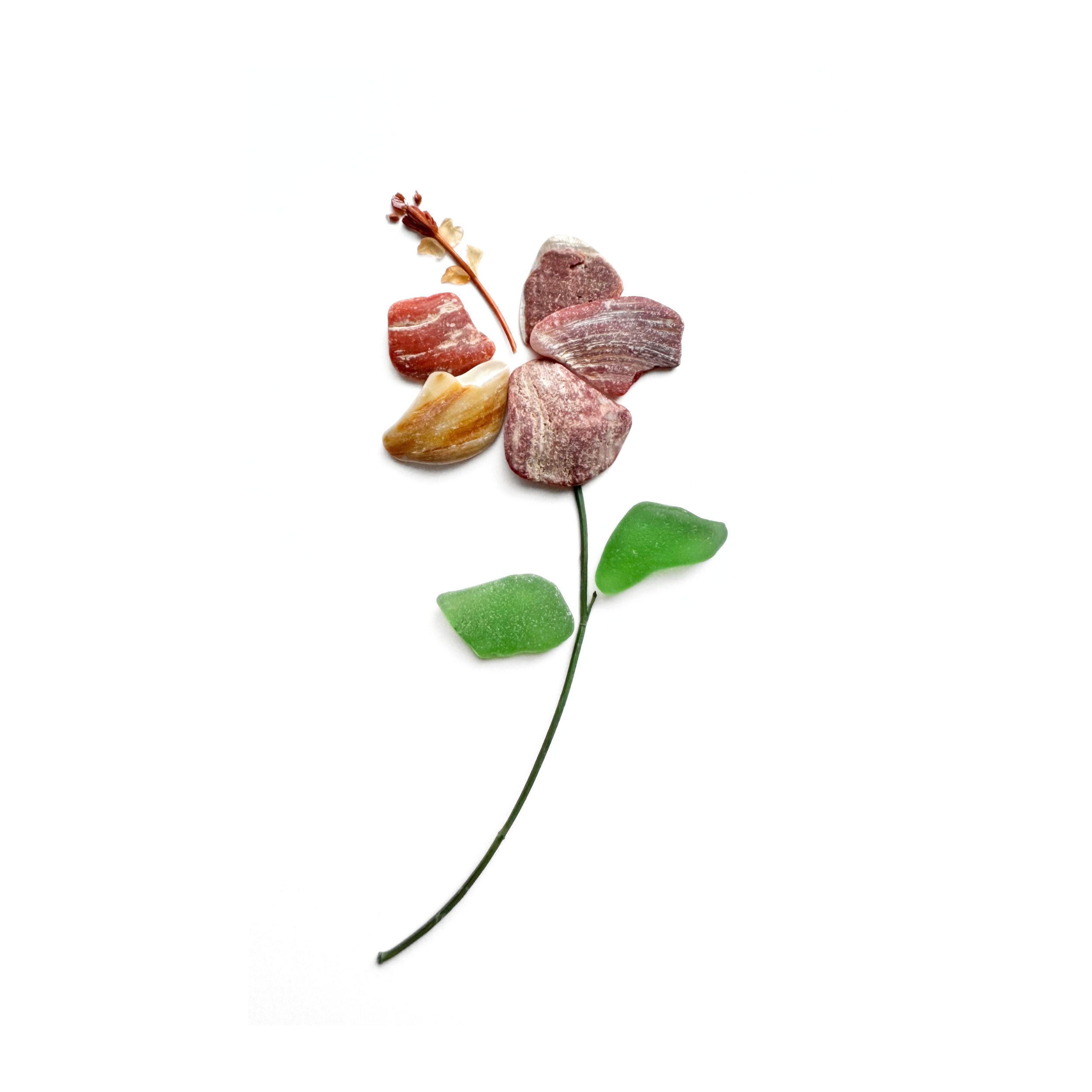 Red abalone and amber sea glass hibiscus with green leaves and a curved natural stem on a white background.