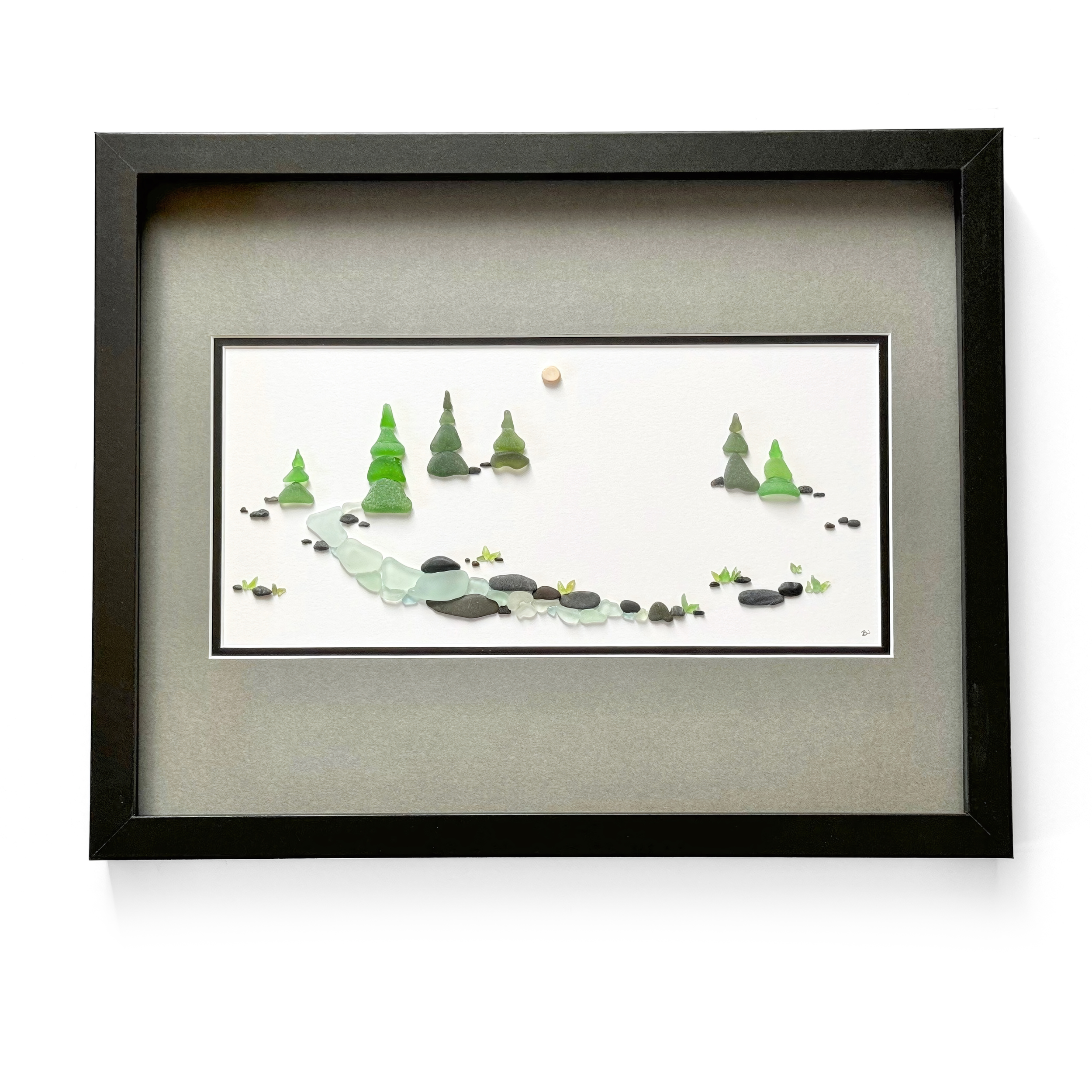 A framed sea glass forest landscape featuring evergreen trees, a winding river, and smooth stones beneath a softly glowing sky.