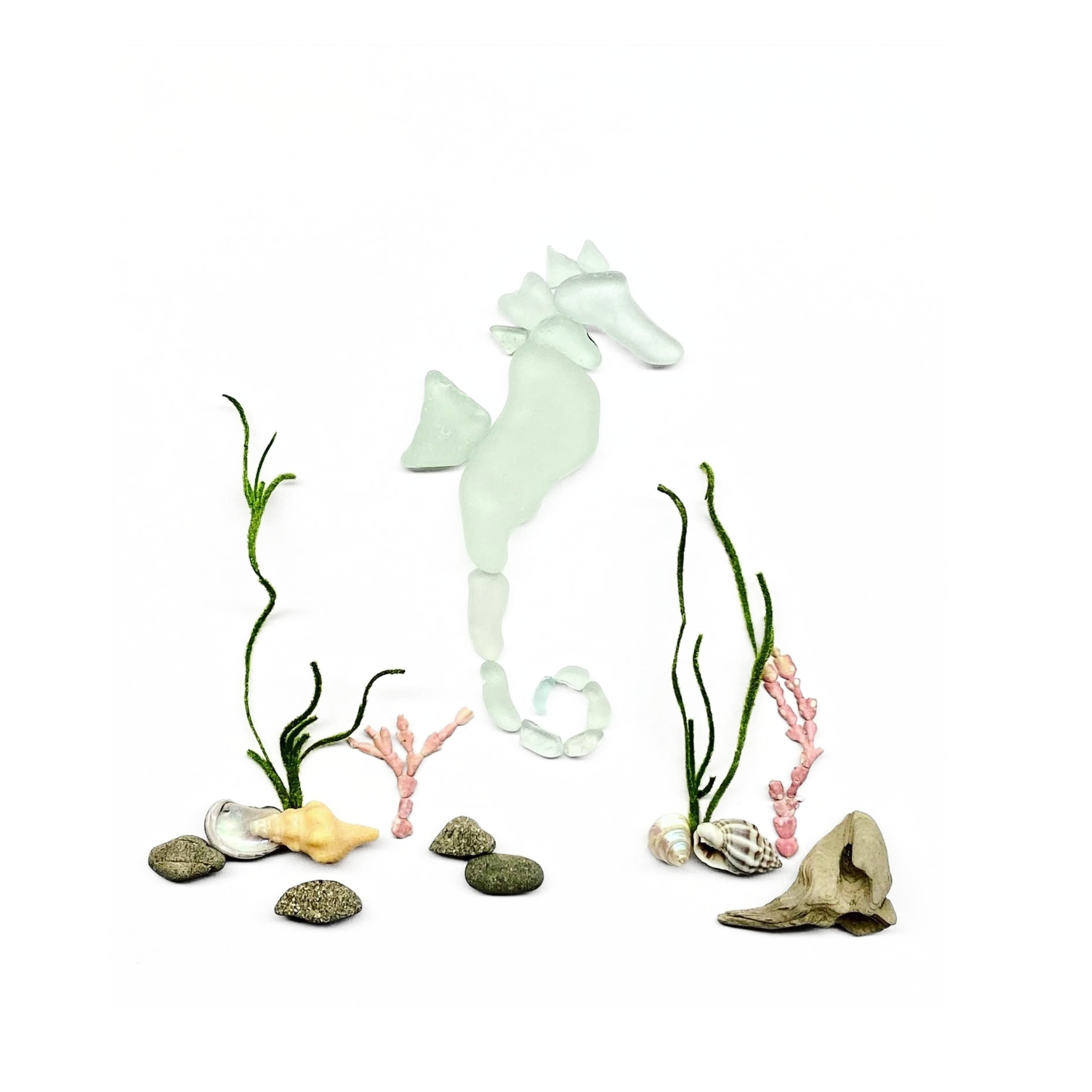 Aqua sea glass seahorse surrounded by an underwater garden of seaweed, shells, and beach stones.