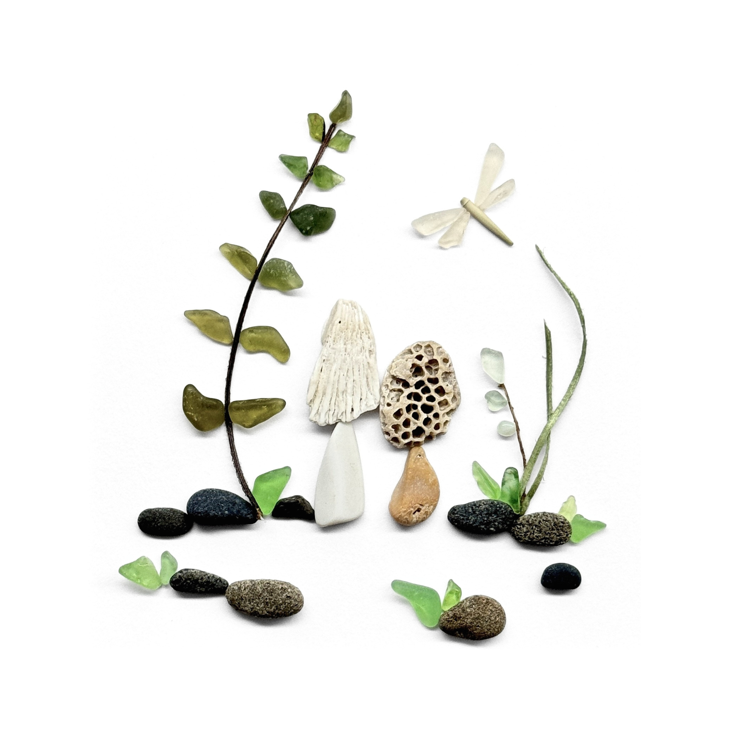 A woodland garden of mushrooms, ferns, and a delicate dragonfly created with sea glass, stones, and preserved botanical elements.