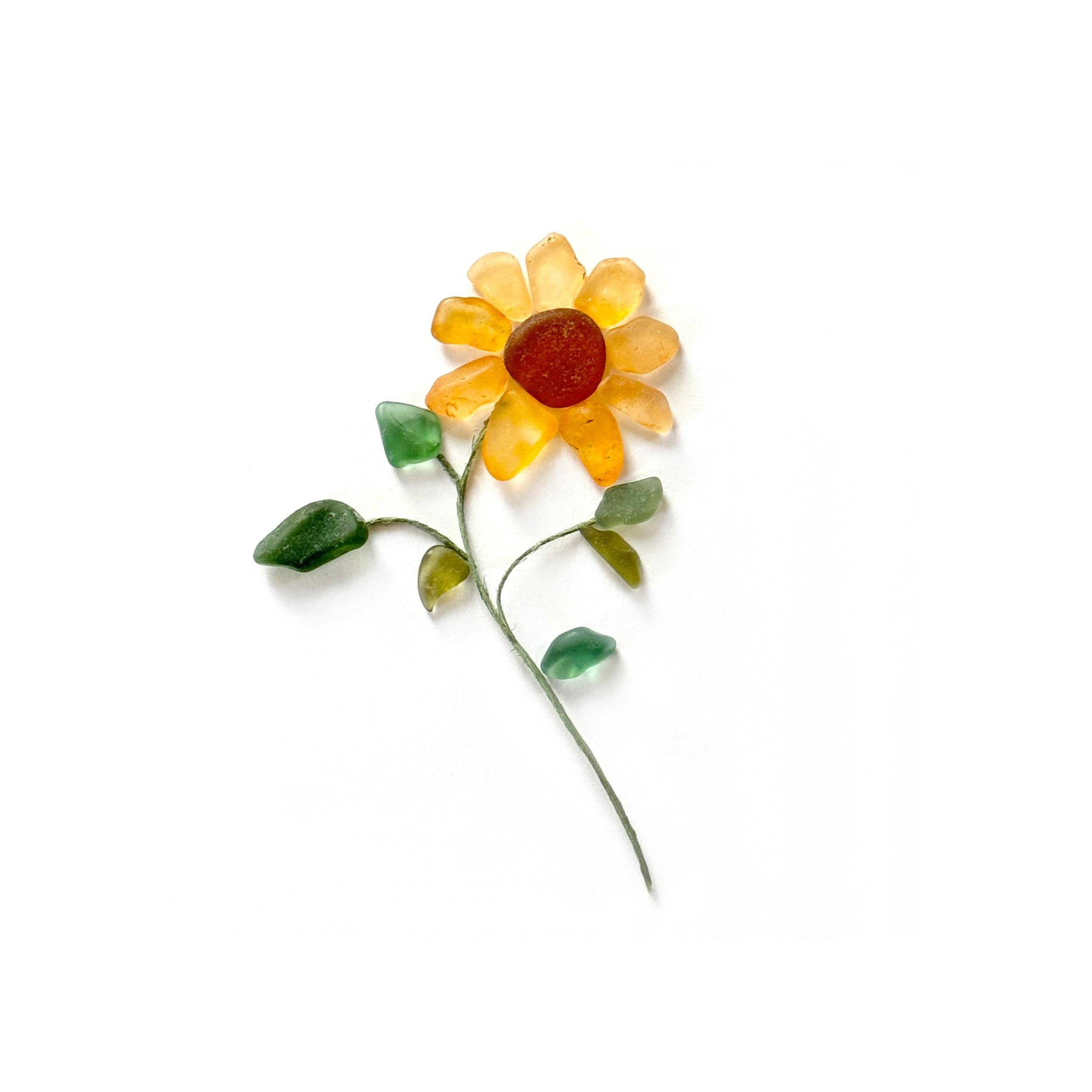 Yellow and orange sea glass sunflower with green leaves on a white background.