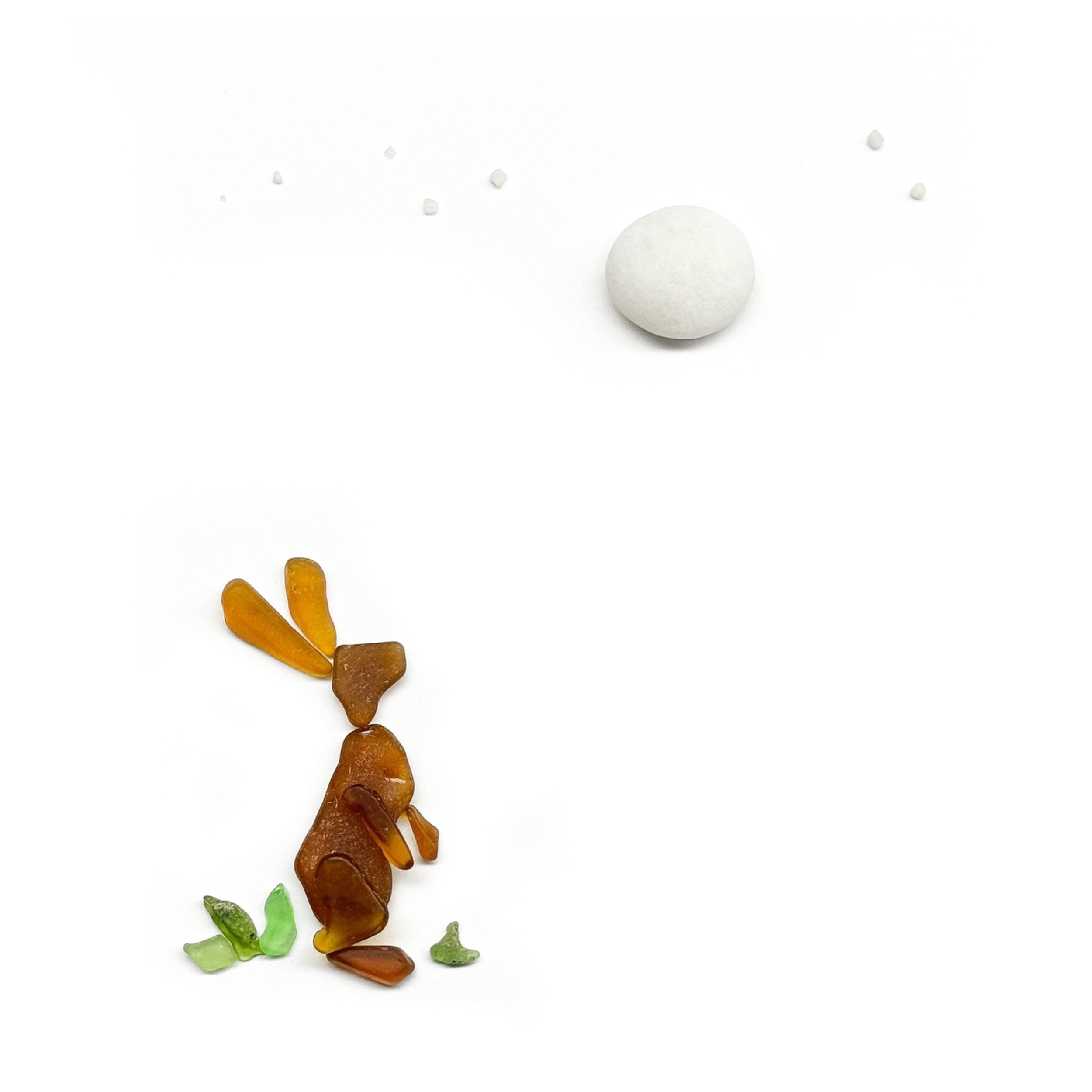 A sea glass rabbit pauses beneath a full moon, surrounded by the smallest signs of spring.