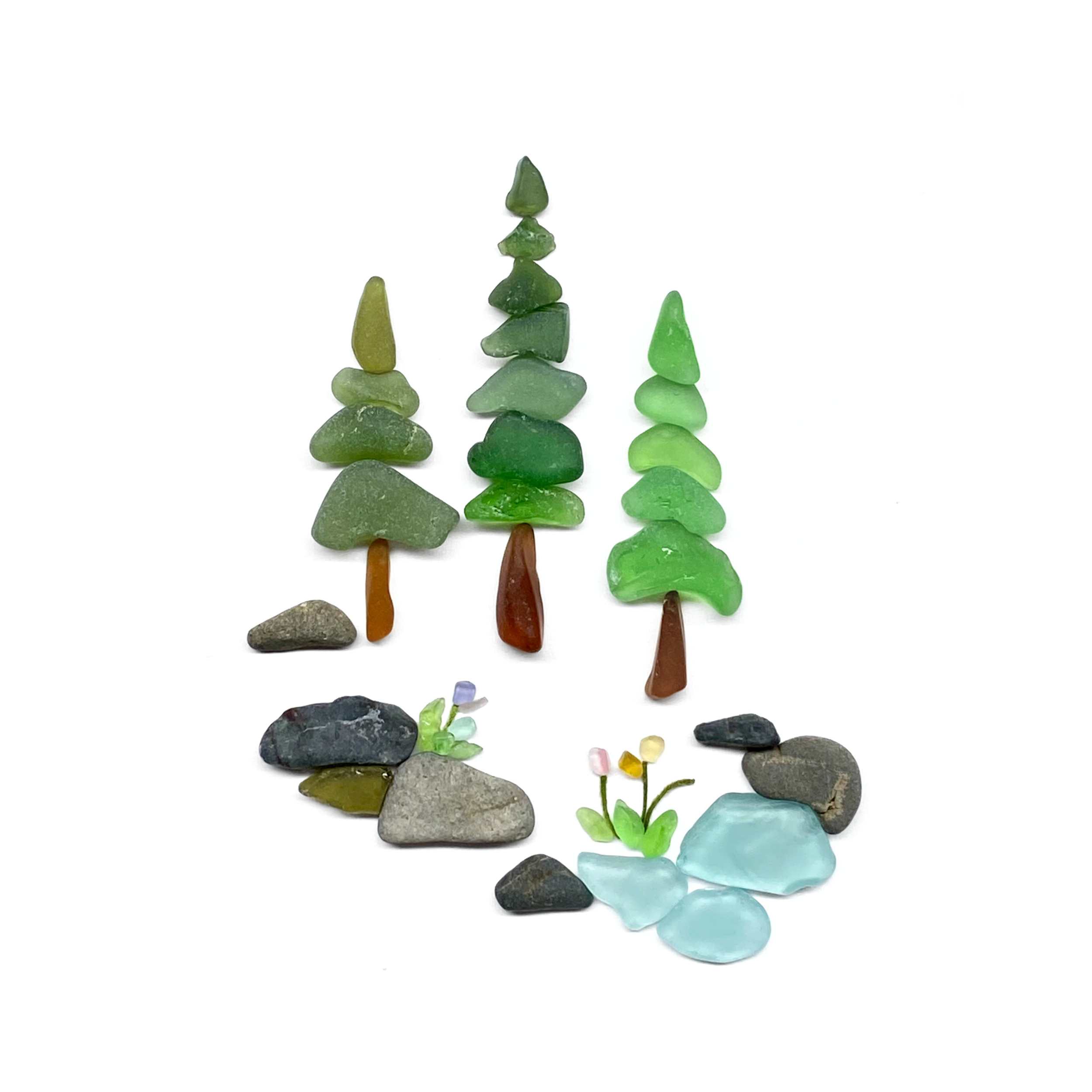 A peaceful forest pond scene featuring sea glass evergreen trees, smooth beach stones, and tiny flowers beside the water.