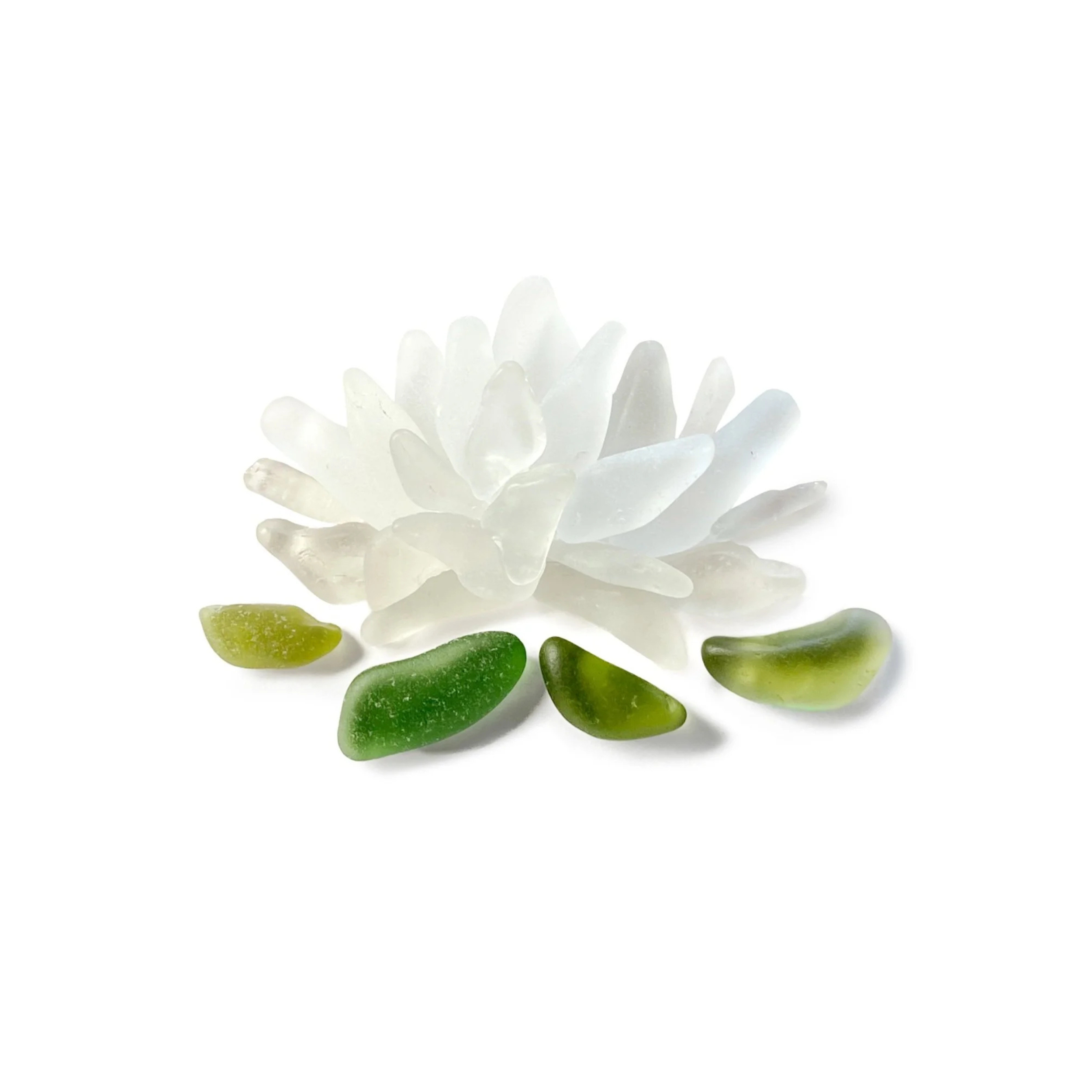 A white sea glass lotus floats on green sea glass lily pads.