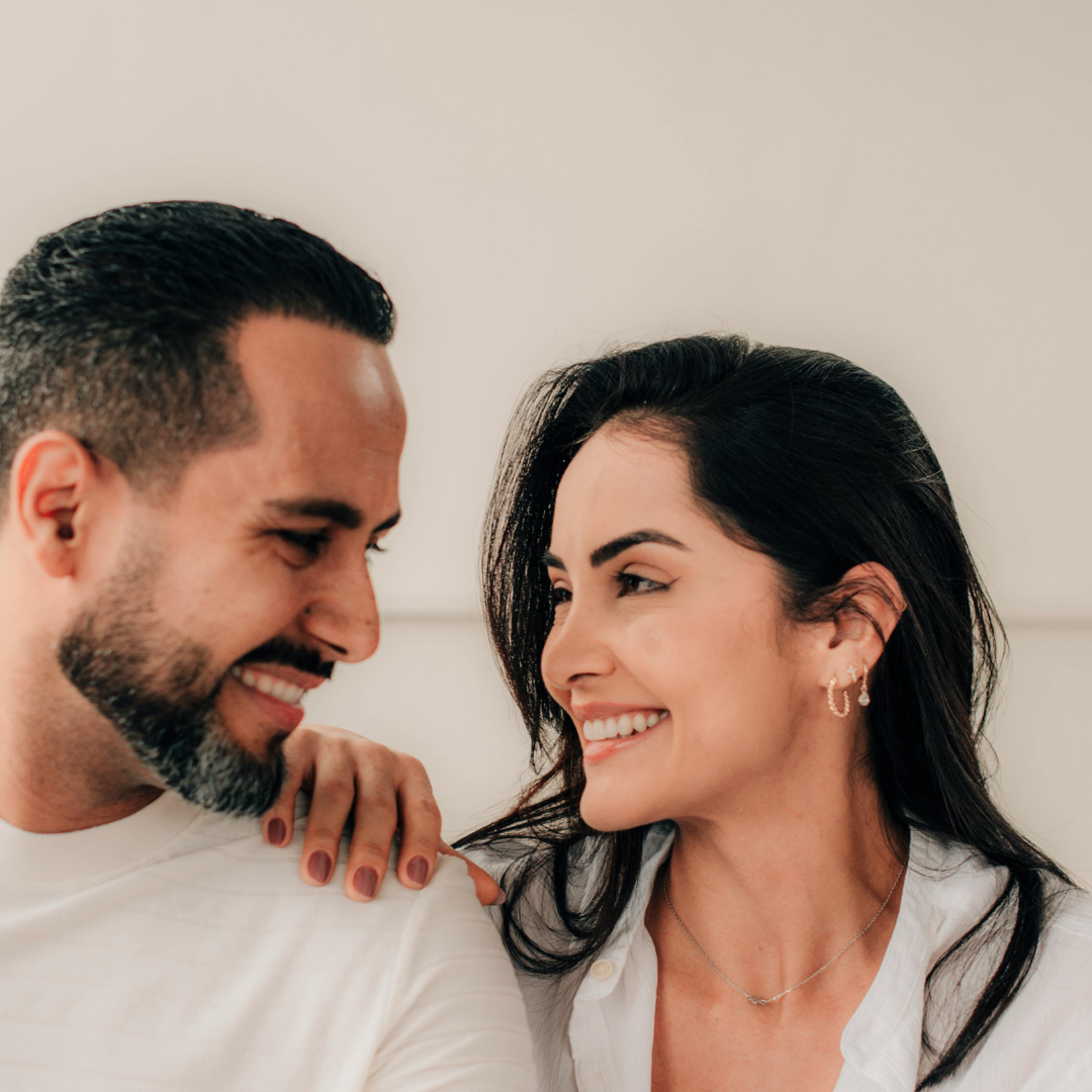 A warm, candid photo of a couple on a date, smiling at each other