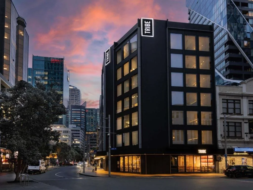 Modern black multi-story building with large windows and