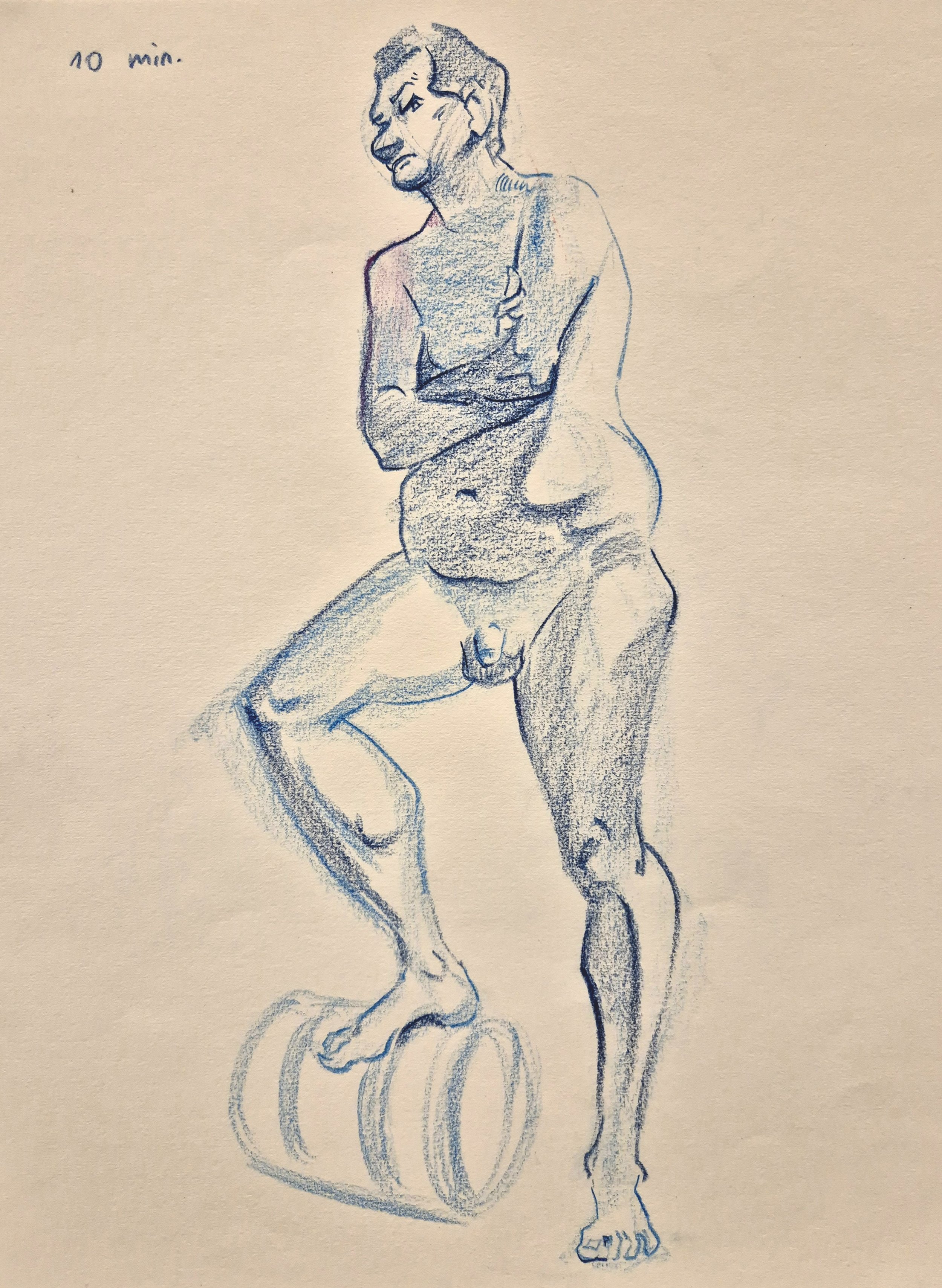 Skizze eines männlichen Aktmodells, das auf einem Holzblock steht, mit verschränkten Armen und einem nachdenklichen Ausdruck, in blauer Buntstiftzeichnung.