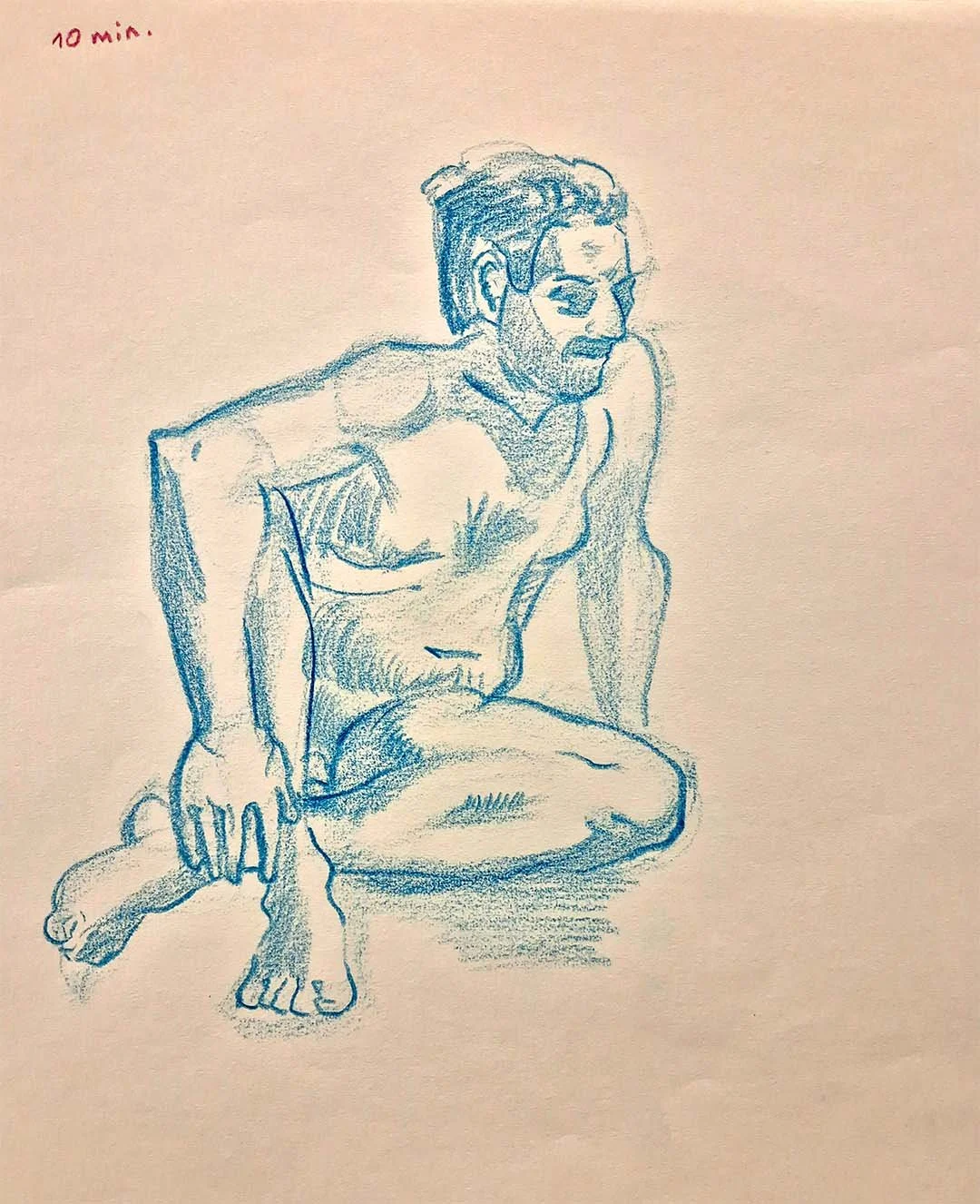 Skizze eines nackten Mannes mit Brille, der auf dem Boden sitzt, in einer krabbelnden Haltung. Der Skizze ist in Blau gehalten, mit Notiz '10 min' in roter Tinte oben links.