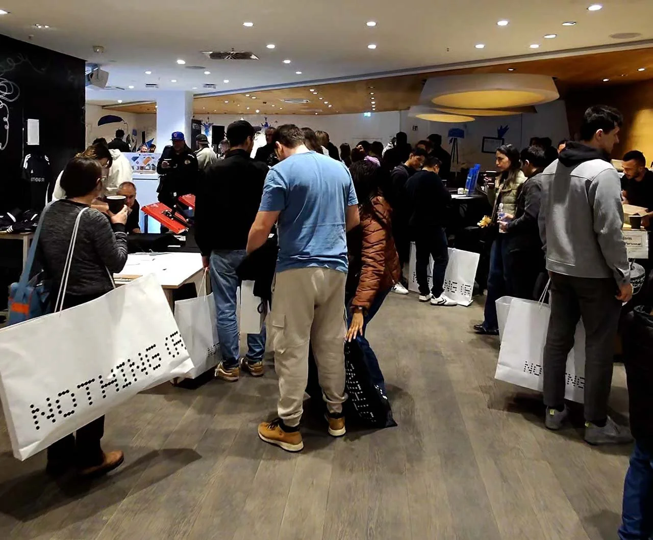 Menschen in einer Menschenmenge in einem modernen Geschäft oder Messe. Sie sind beim Einkaufen oder beim Anstehen an Ständen, um Produkte zu kaufen oder Informationen zu erhalten.